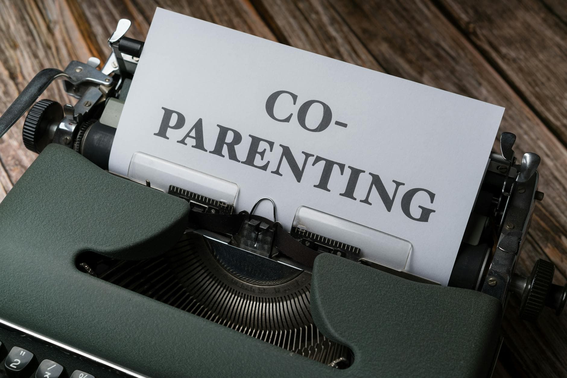 Close-up of a typewriter with a co-parenting document, symbolizing effective collaboration. - co-parenting communication winter break