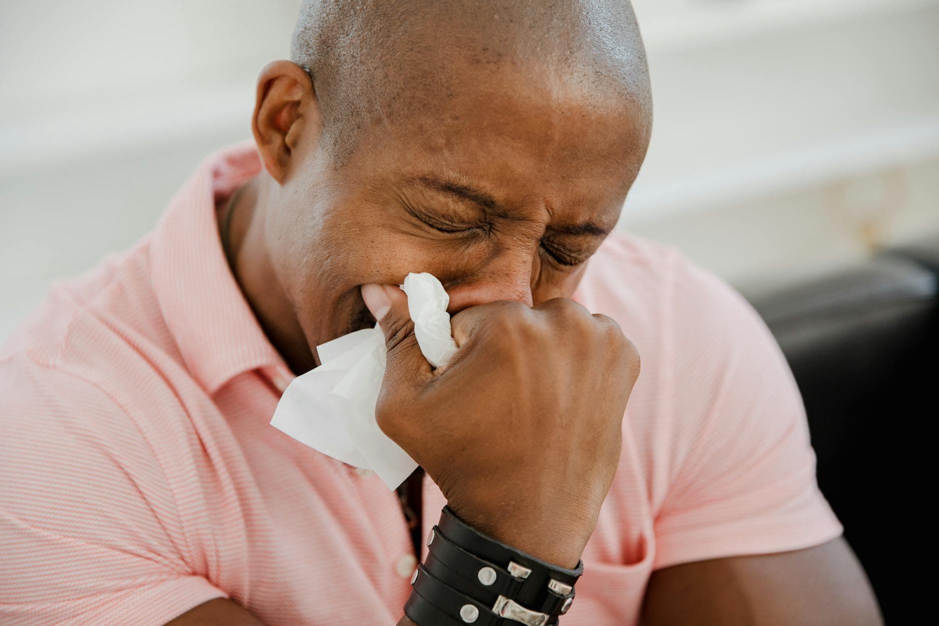 A close-up image of a black man in a pink shirt expressing strong emotions. - light therapy for sad