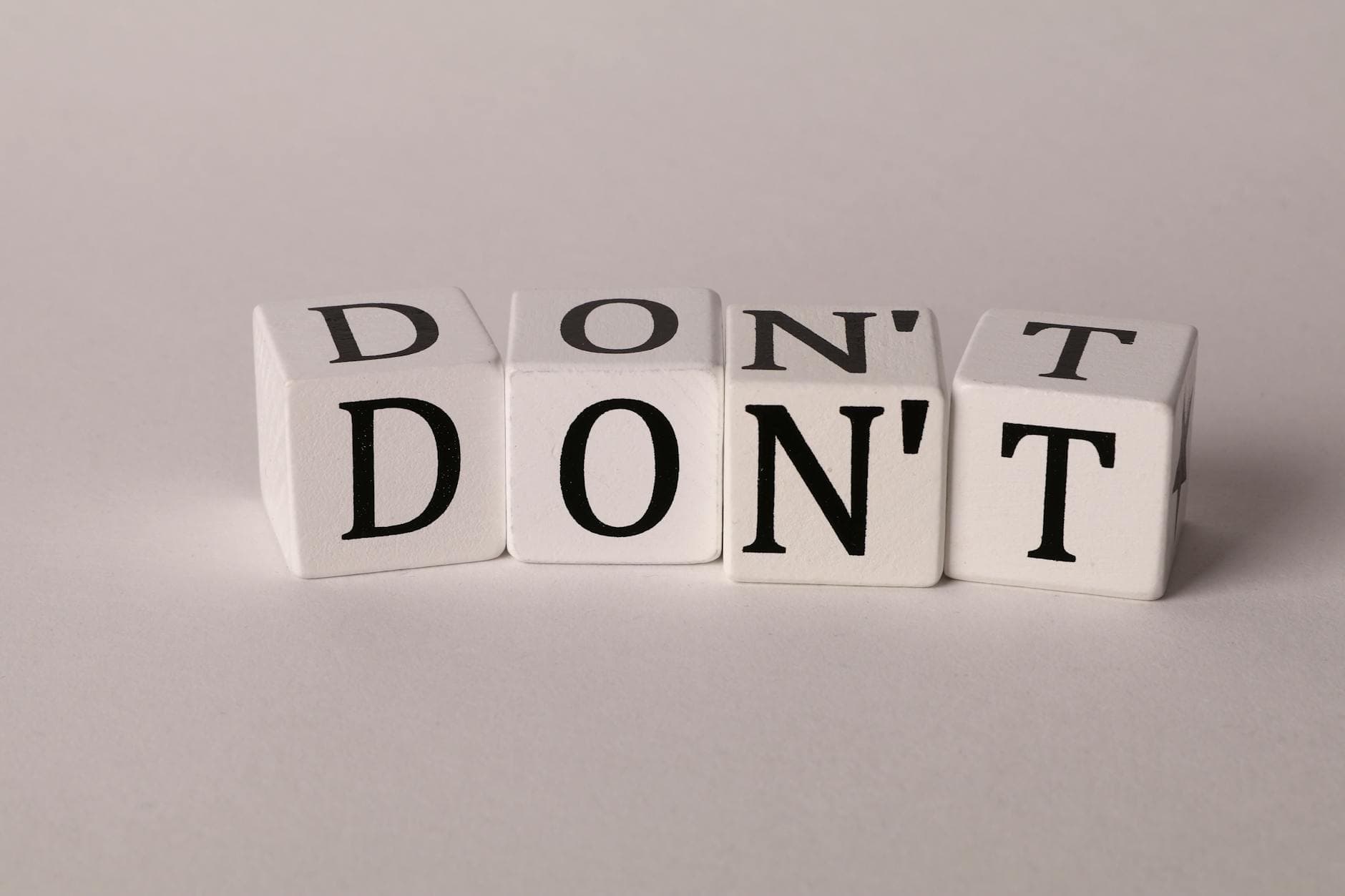 Text cubes spelling 'DON'T' on a clean white background, ideal for concepts of caution or prohibition. - marriage advice to avoid