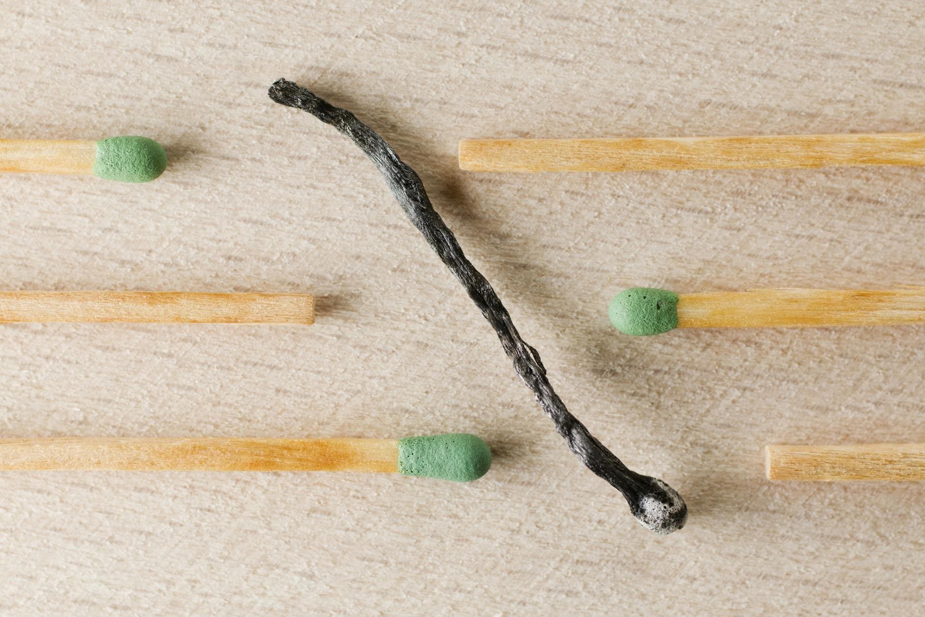 Charred match surrounded by green-tipped matches symbolizing burnout and contrast. - overcome winter isolation