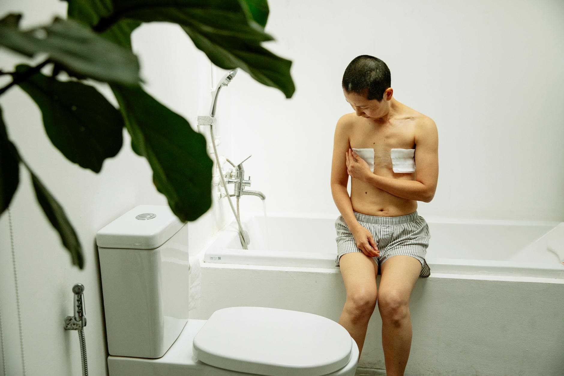 Asian woman with short hair in bathroom recovering from surgery, showing resilience and hope. - post-holiday relationship struggles