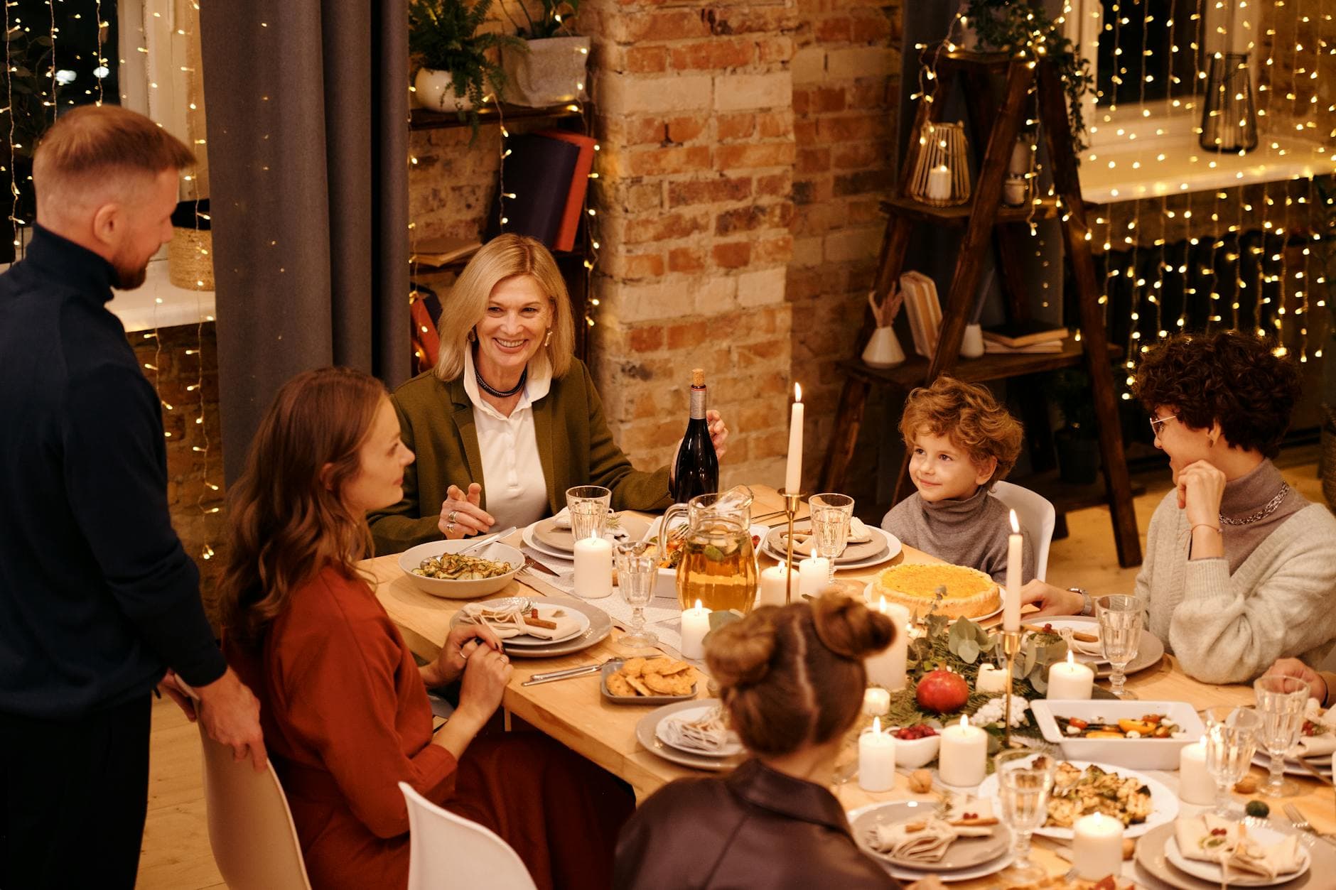 Warm family gathering enjoying Christmas dinner with festive decor and lights. - setting boundaries family gatherings