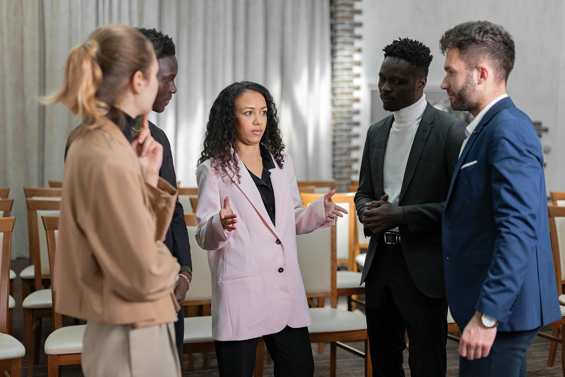 Group of well-dressed professionals having a focused conversation indoors. - active listening steps