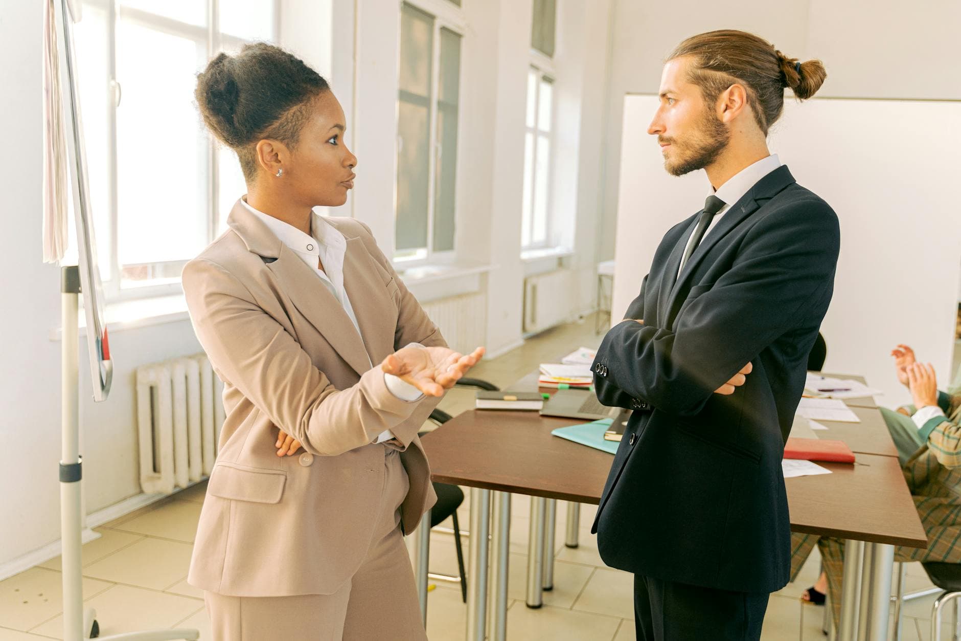 Business professionals in conversation during a meeting in a modern office environment. - assertive communication examples
