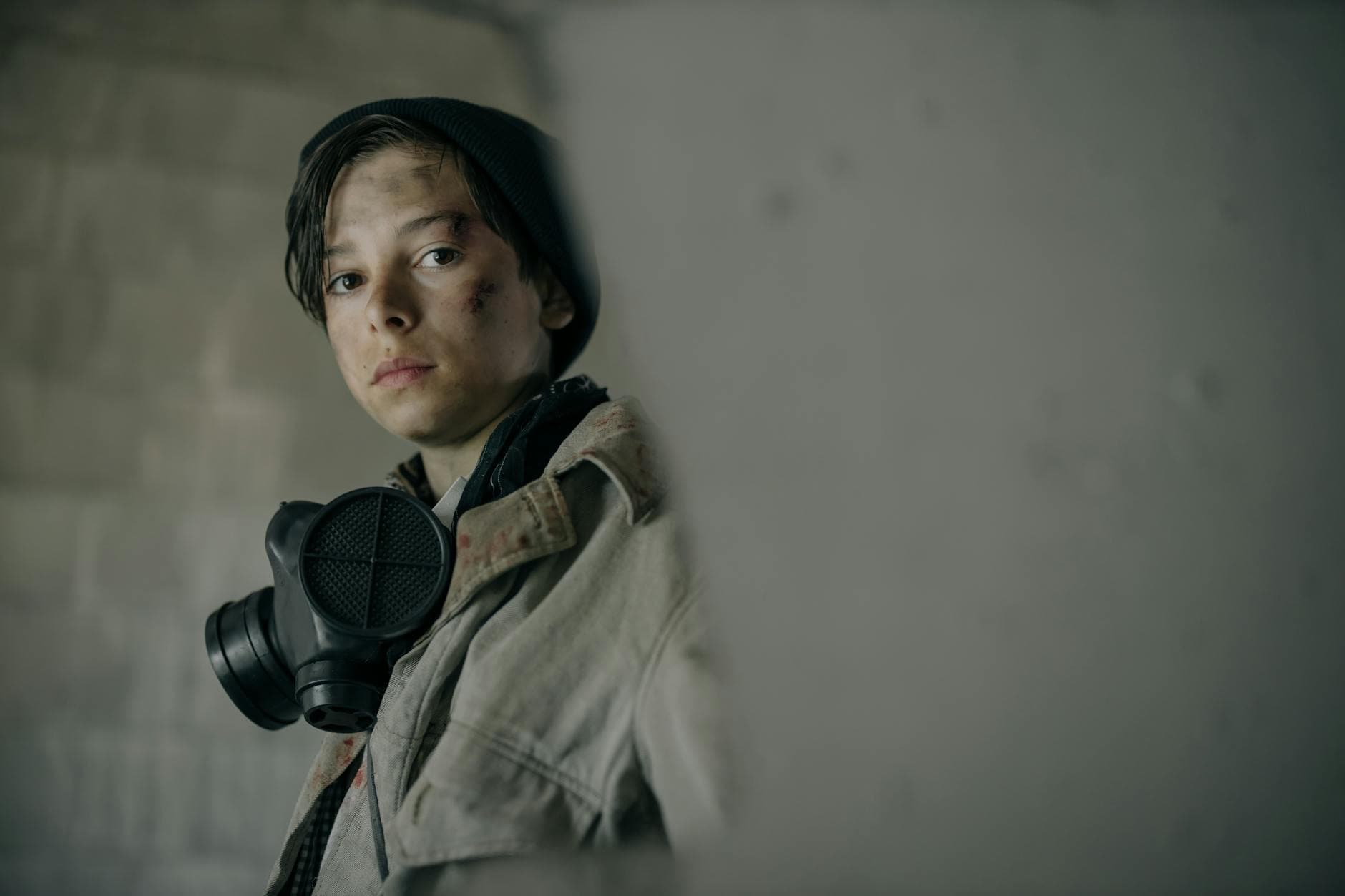 Teen in a respirator, embodying resilience in a desolate urban environment. - building resilience