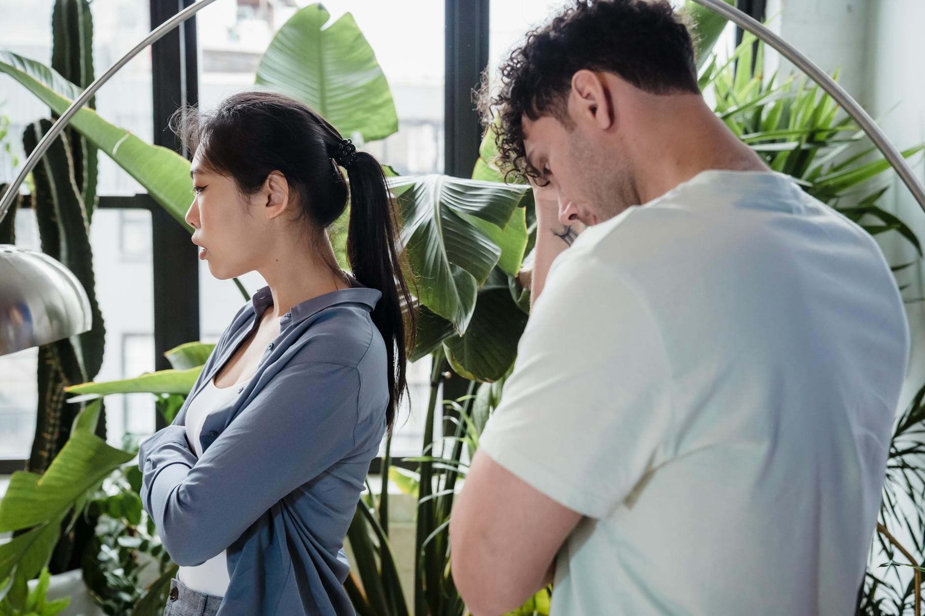 A couple argues in a lush indoor garden, creating a tense atmosphere. - what is conflict