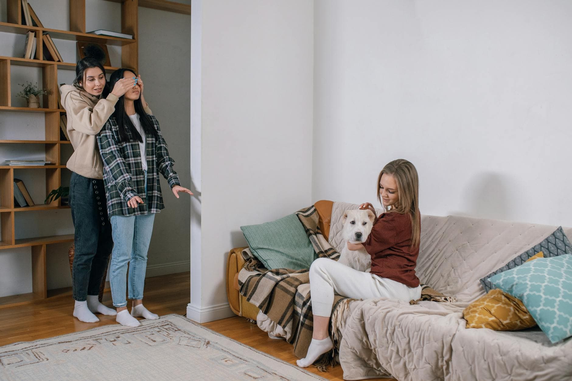 Three women share a joyful moment with a surprise gift—a cute dog, creating a heartwarming scene. - dating after long break