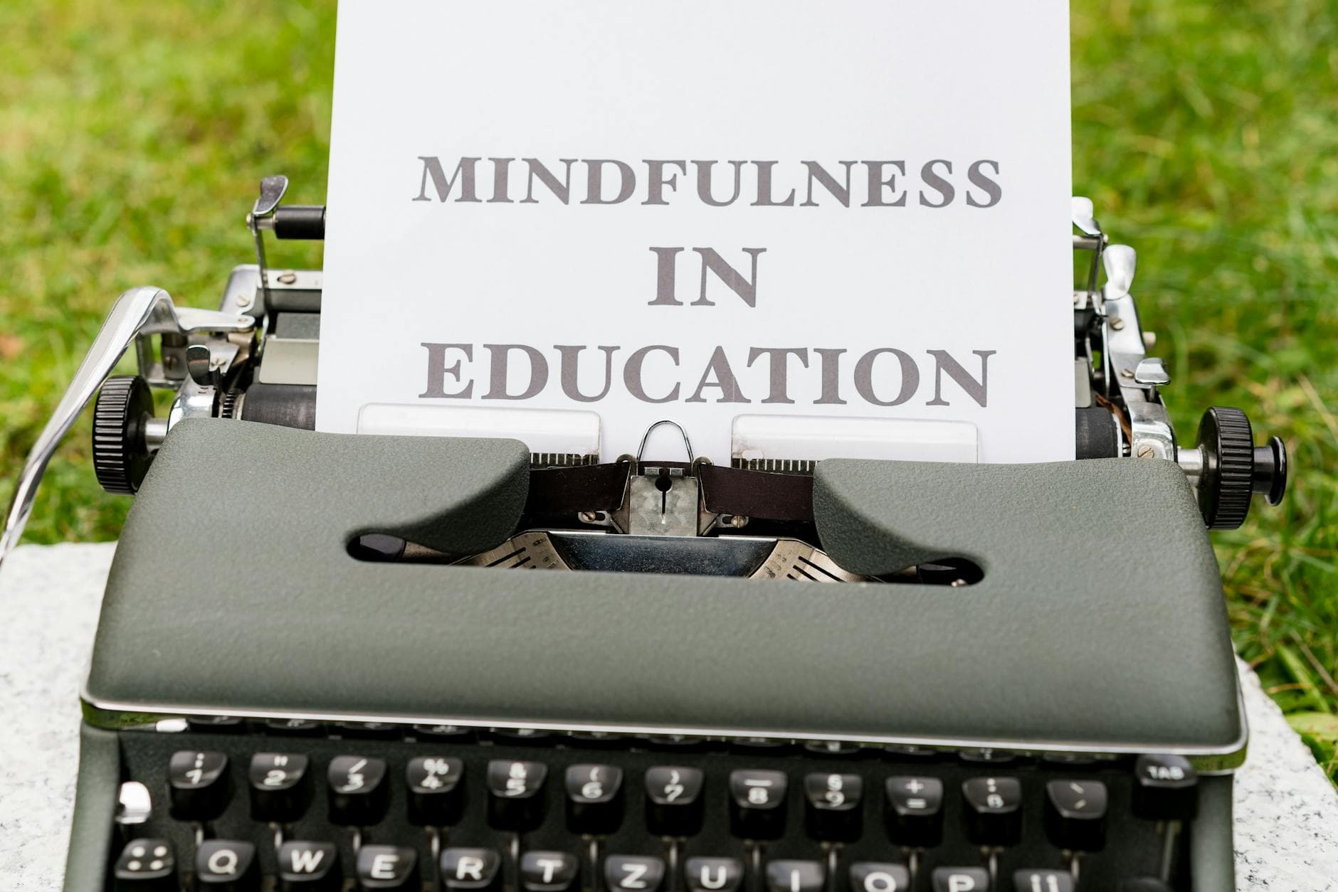 A vintage typewriter showcasing 'Mindfulness in Education' concept outdoors. - mindfulness for stress