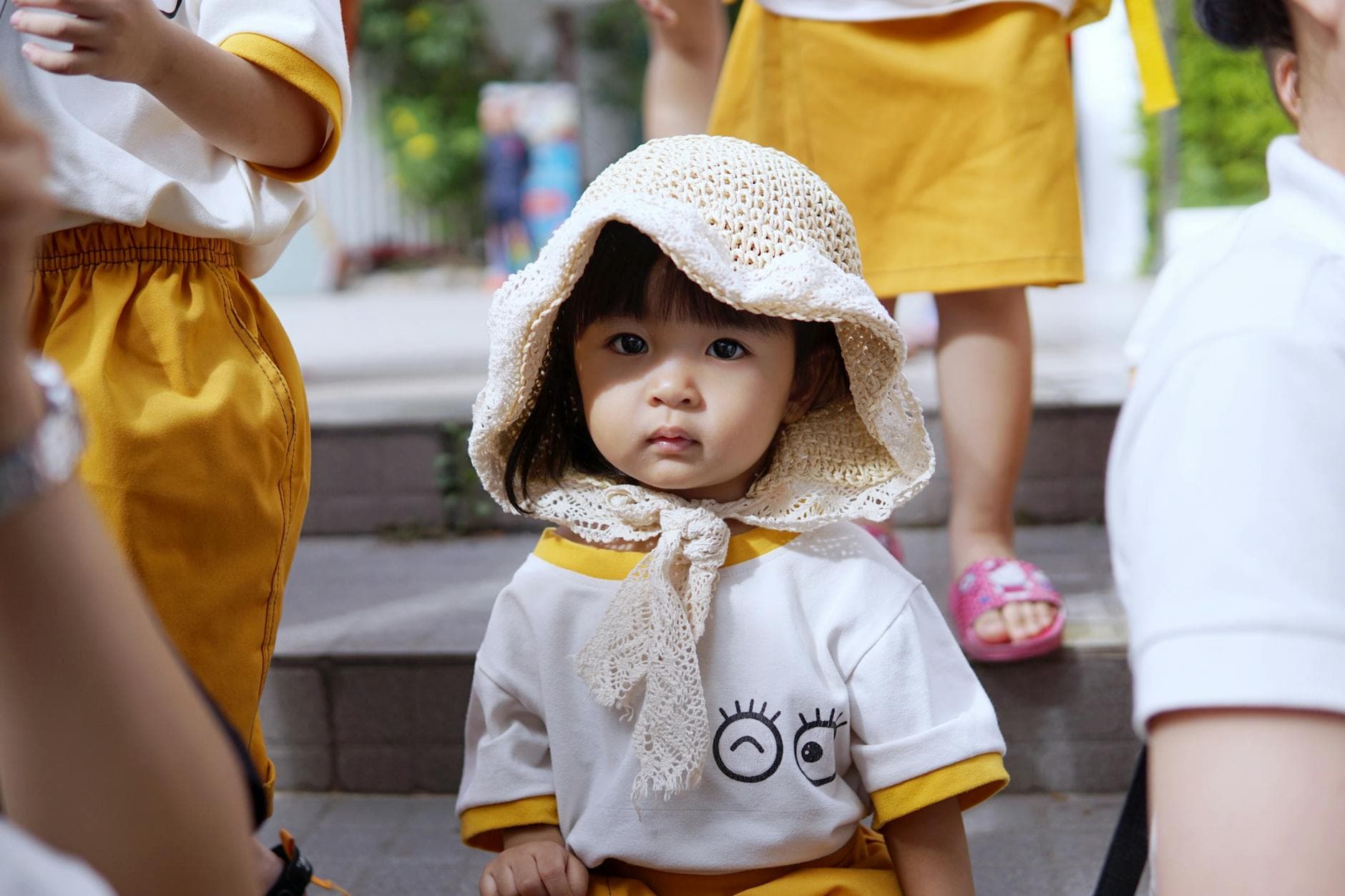Adorable young girl in school uniform and knitted hat outdoors. - preschool social skills