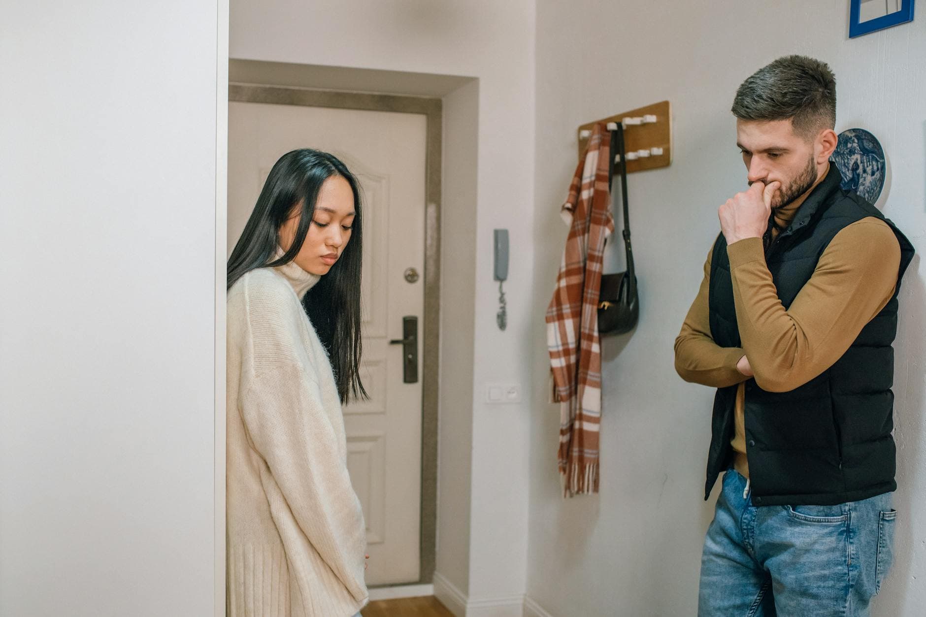 An interracial couple experiencing a tense moment inside their home. - relationship emotional baggage
