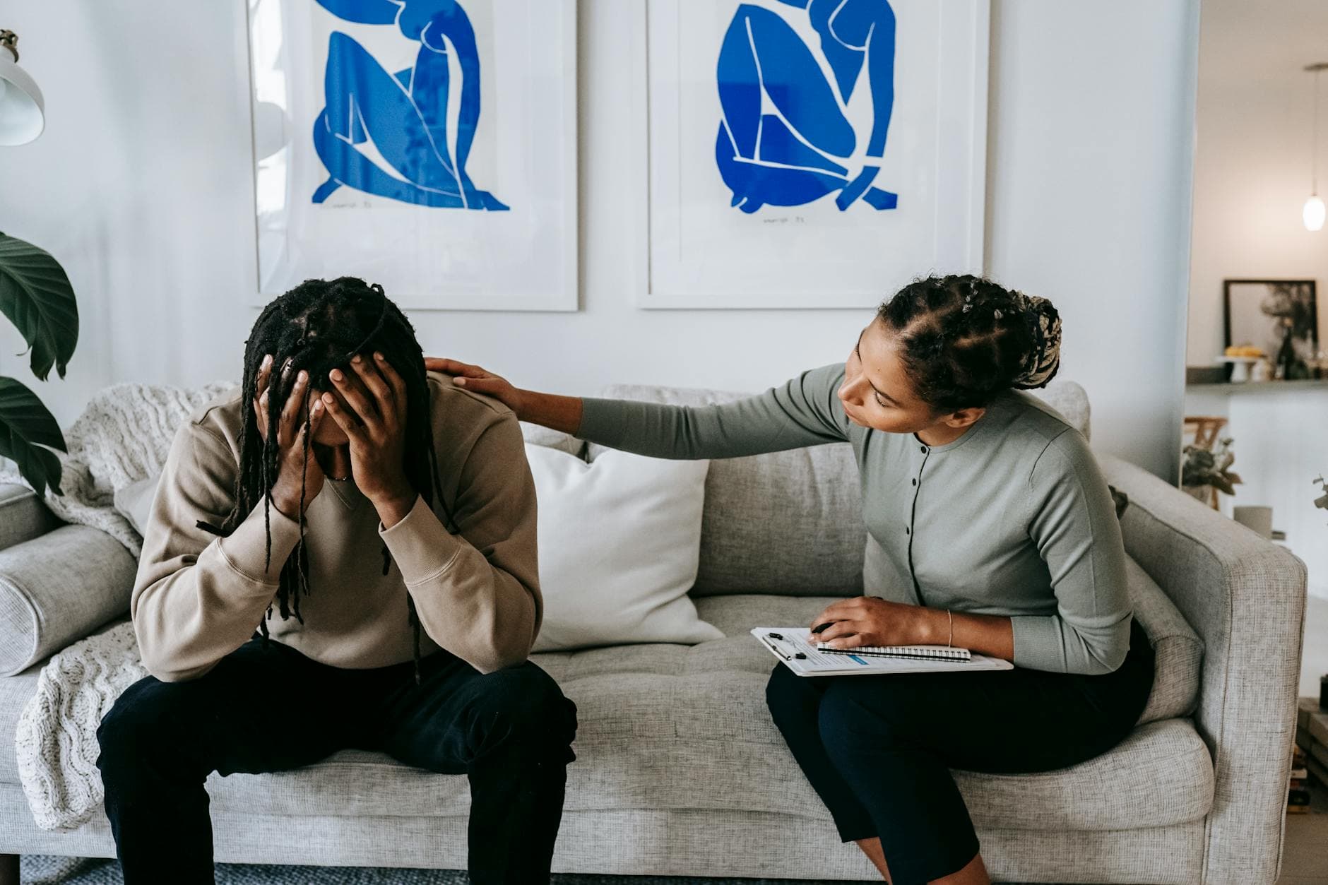 A couple sharing a moment of support and understanding on a living room sofa, depicting comfort. - sadness therapy spring