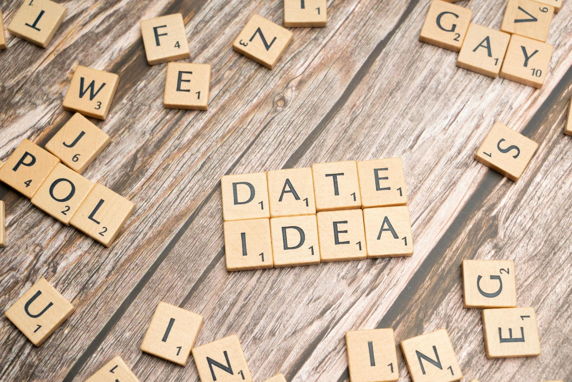 Letter tiles spelling 'Date Idea' on a wooden surface, suggesting creative meeting plans. - spring outdoor date ideas