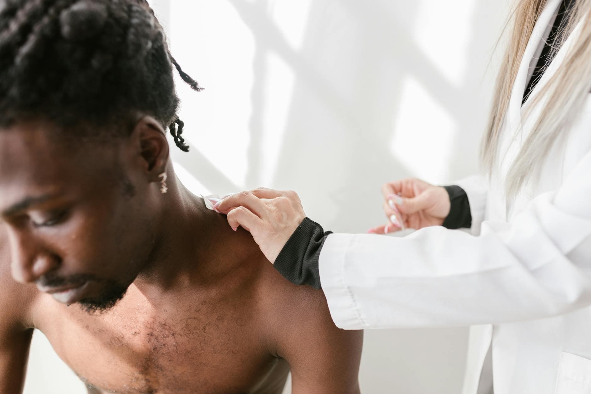 Close-up of a man receiving a shoulder massage for pain relief indoors. - spring stress relief