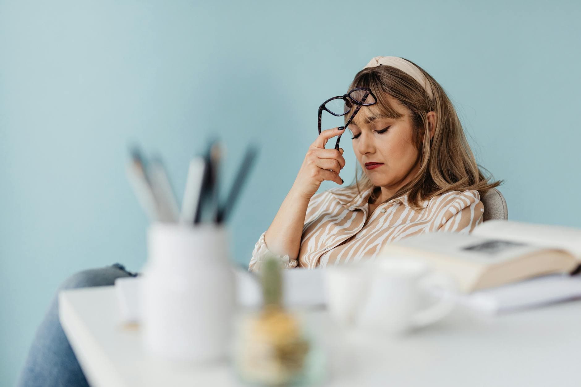Caucasian woman looks exhausted while taking a break with eyes closed at her desk. - therapy for burnout