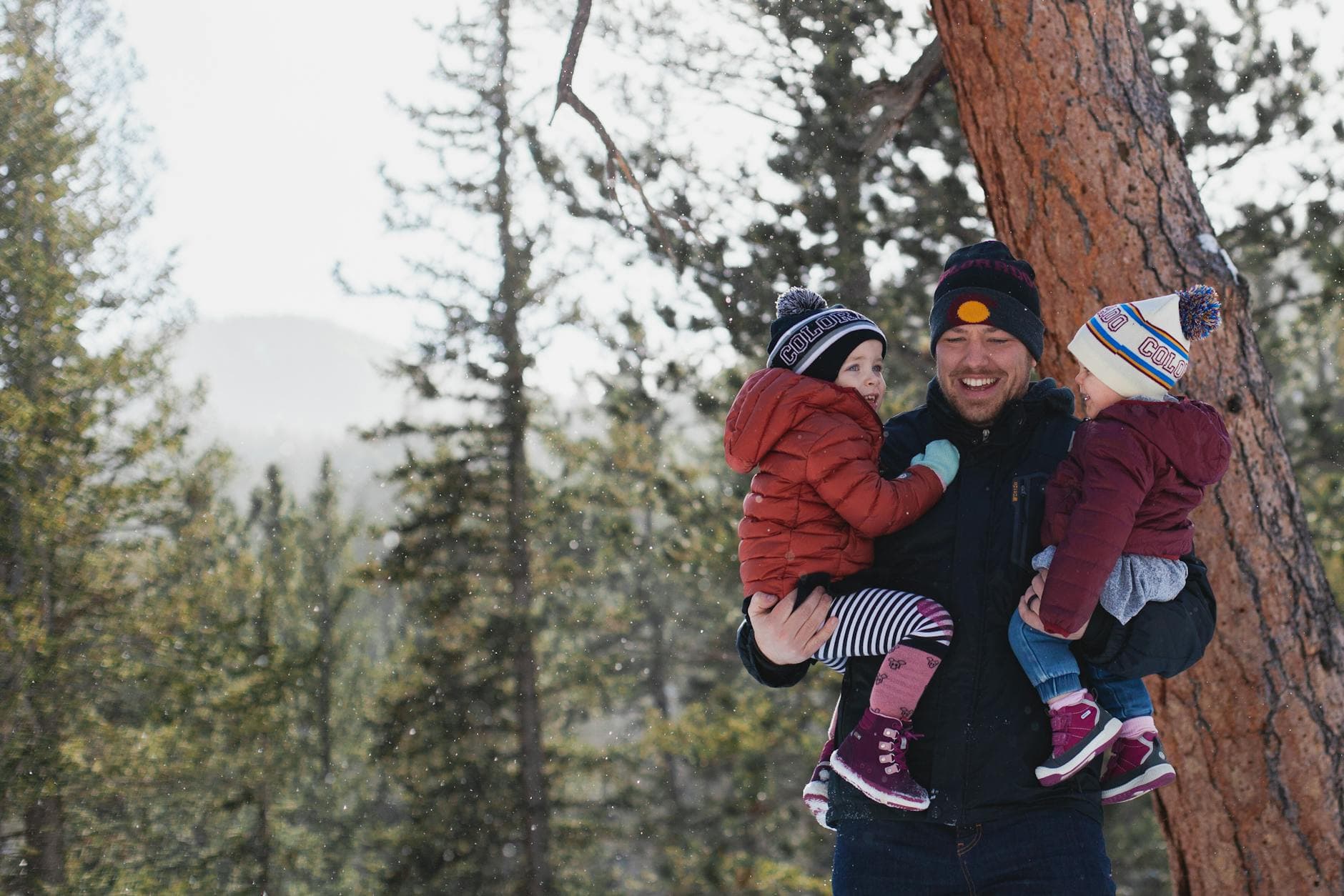 A joyful father holding his children in a snowy forest during winter, creating lasting memories. - winter anxiety children