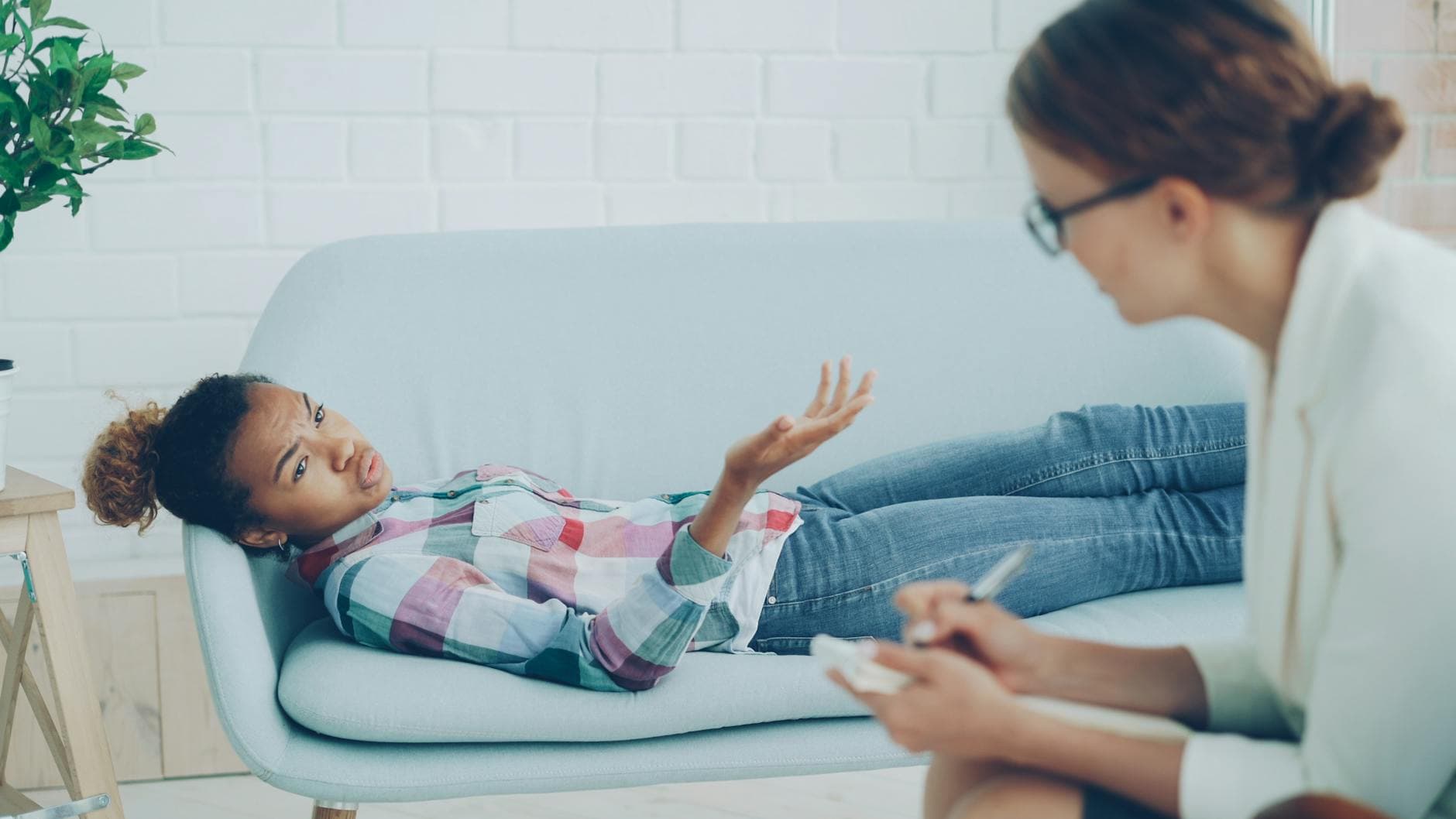 A therapy session with a psychologist and a patient on a sofa, focusing on emotional well-being. - mental well-being therapy