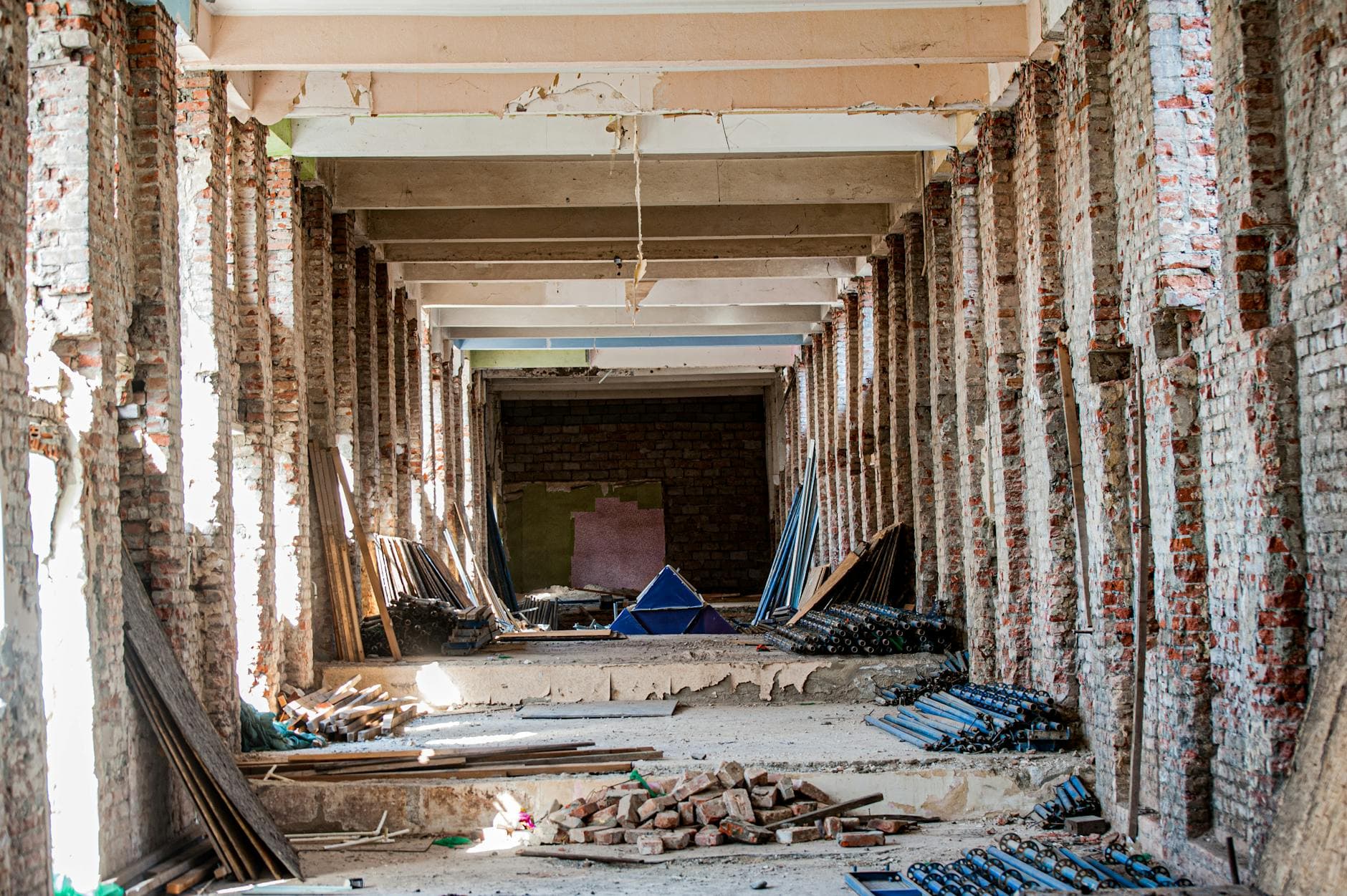 An empty industrial interior undergoing renovation, with exposed brick and construction materials. - renovation communication needs