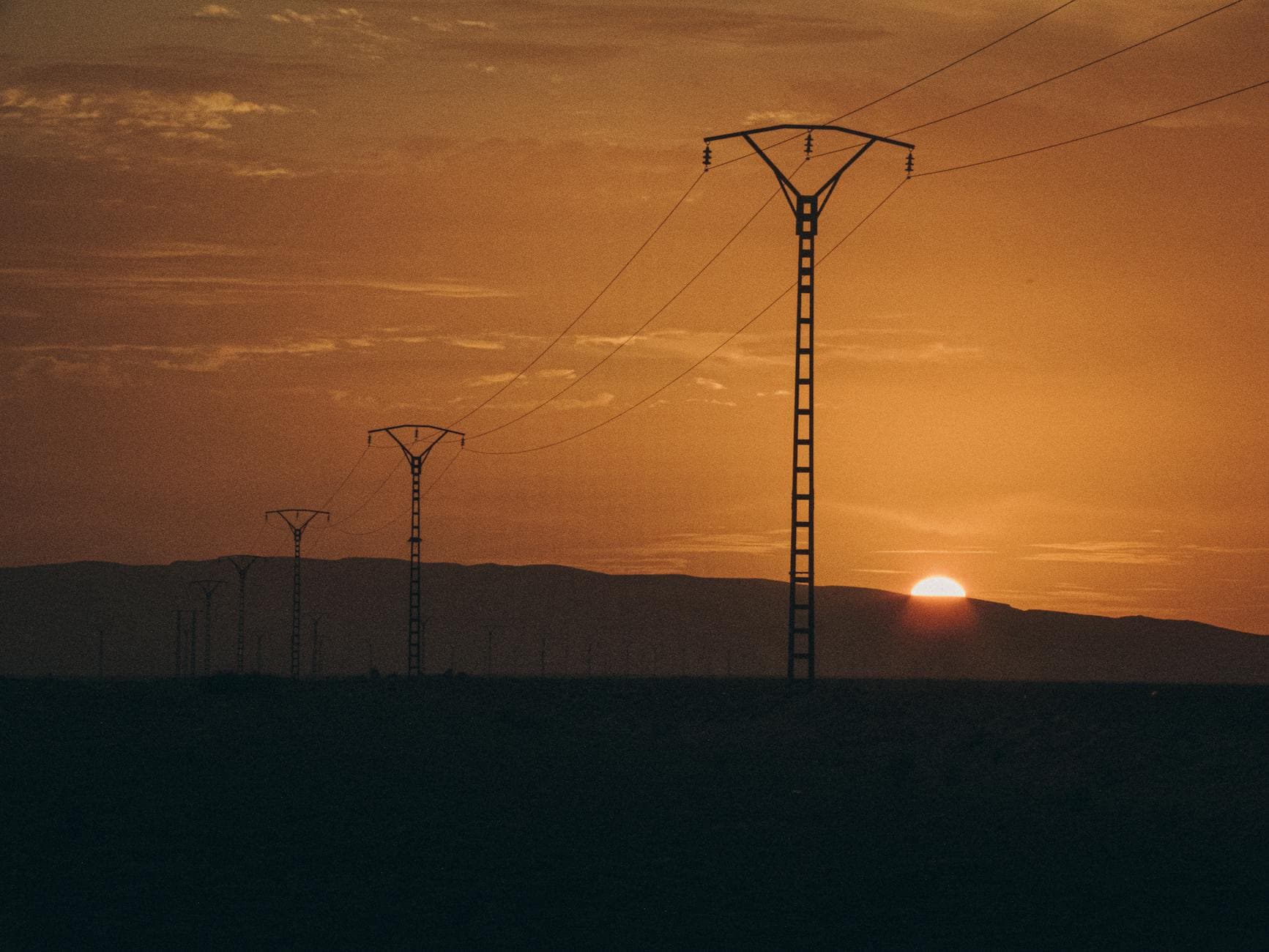 Serene Algerian landscape with power lines stretching into the distance at sunset. - long distance summer