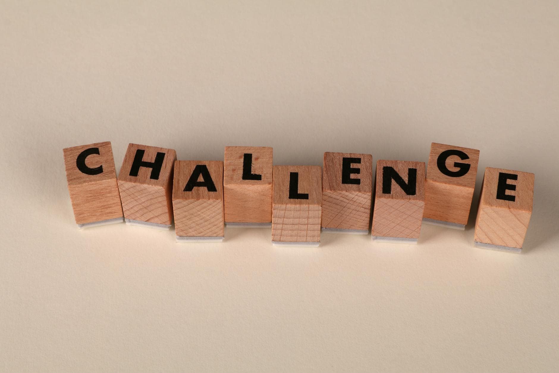 Wooden blocks arranged to spell 'Challenge' against a neutral backdrop, symbolizing overcoming obstacles. - overcome perfectionism