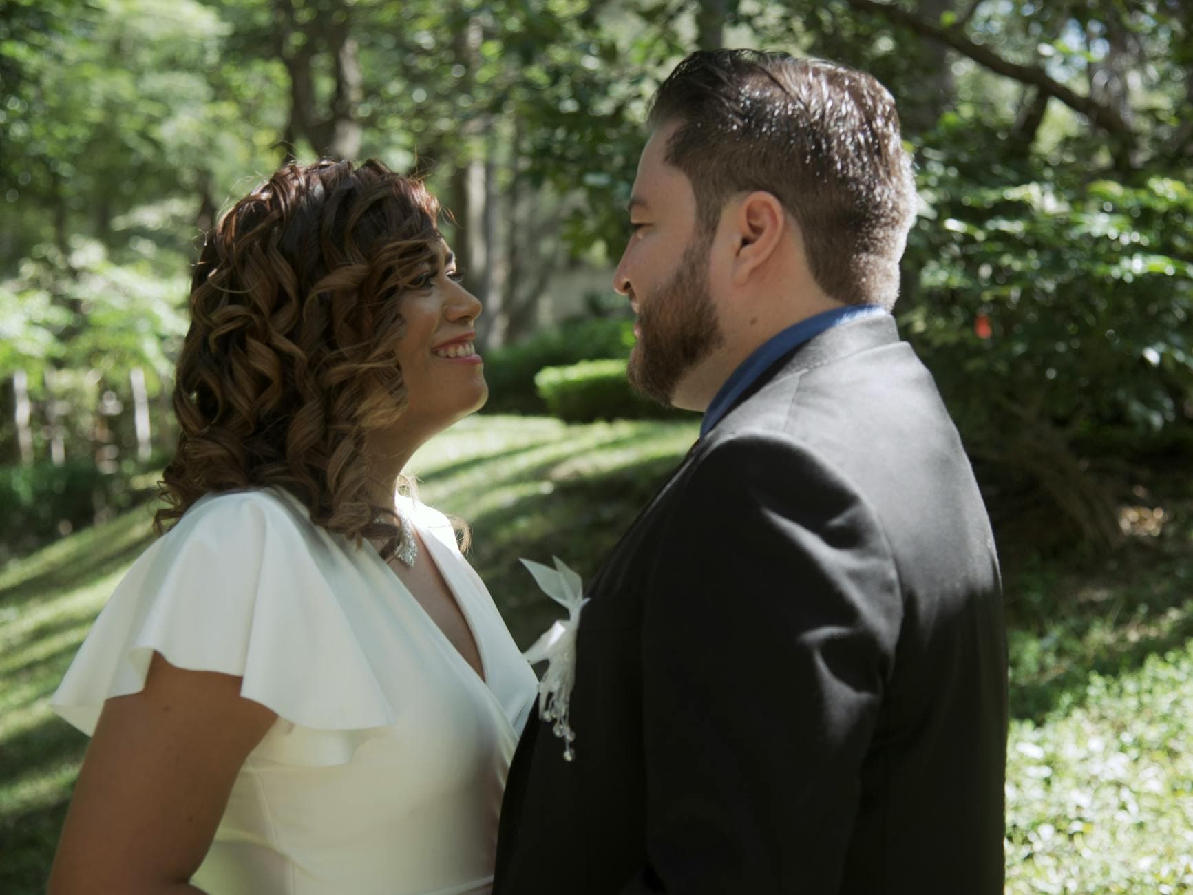 A couple sharing a joyful moment at their wedding outdoors amidst lush greenery. - post wedding connection