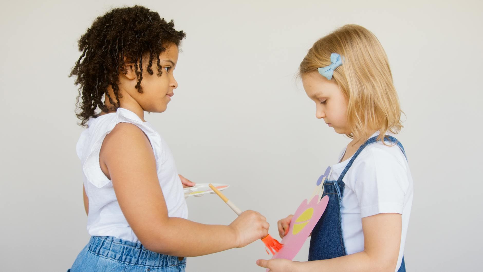 Two young girls painting together, exploring creativity with arts and crafts indoors. - preschool playdate ideas