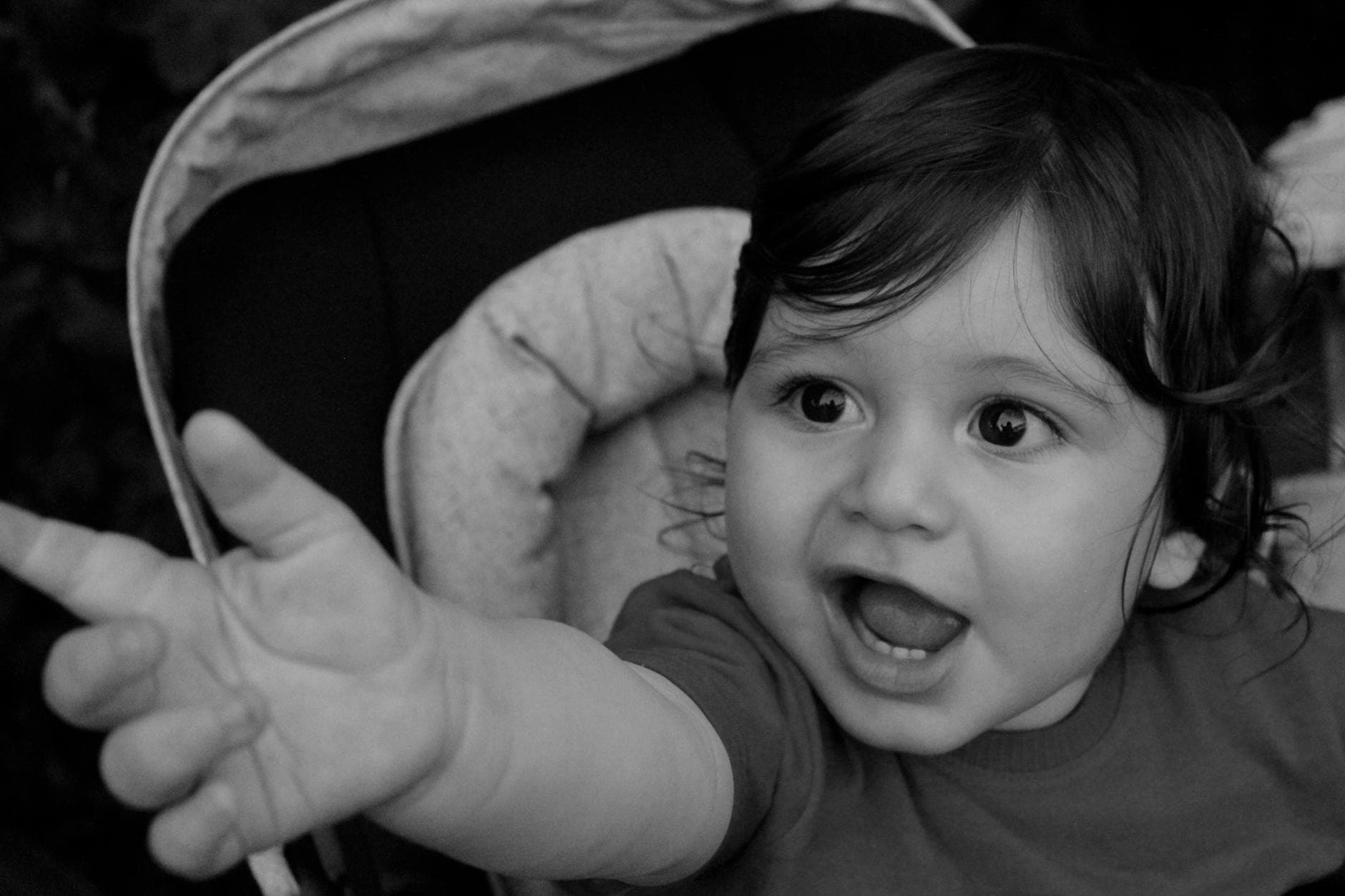 Black and white photo of a joyful child reaching out, capturing innocence and curiosity. - toddler sleepaway camp