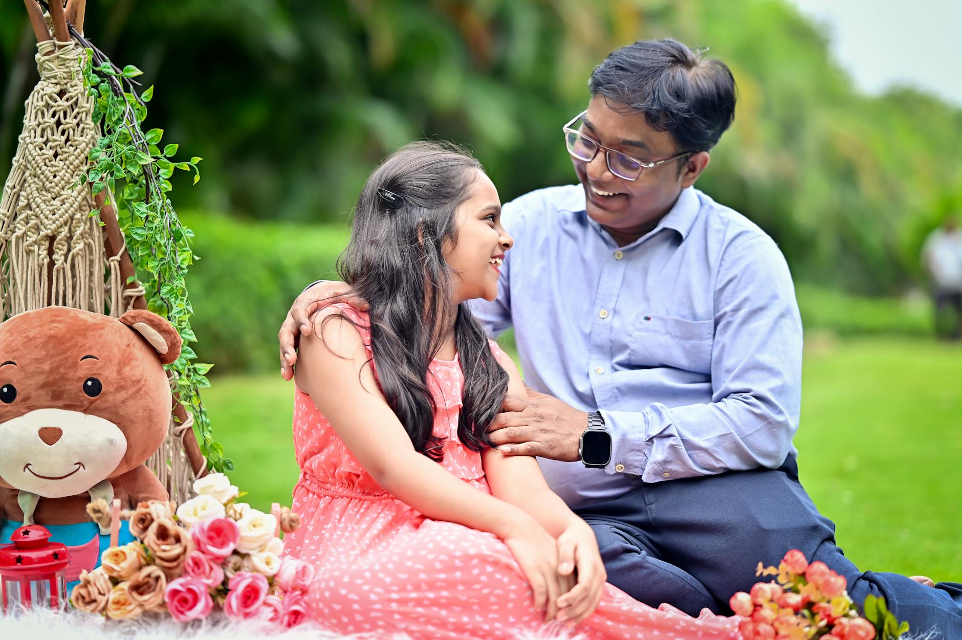 Happy father and daughter bonding during a cheerful outdoor picnic in a garden. - anger management near me