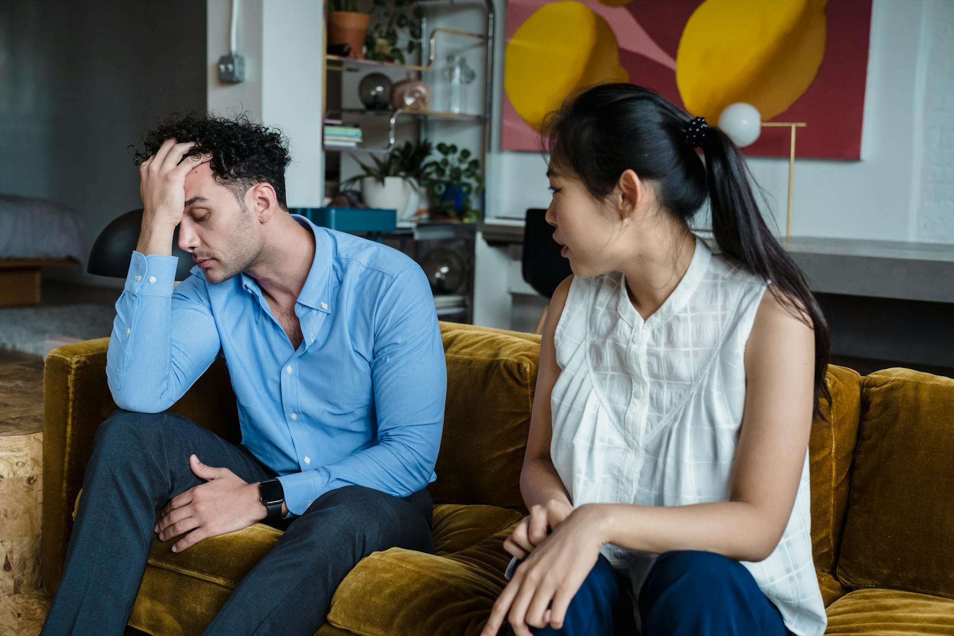Upset couple in a heated discussion sitting together indoors on a sofa. - anxiety in romantic relationships