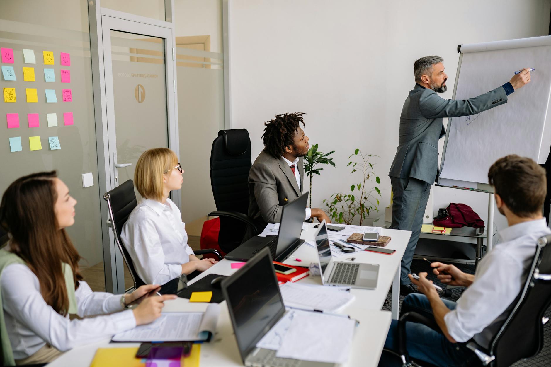 Business team engaged in a collaborative meeting with a leader presenting on a flip chart. - blended family communication strategies