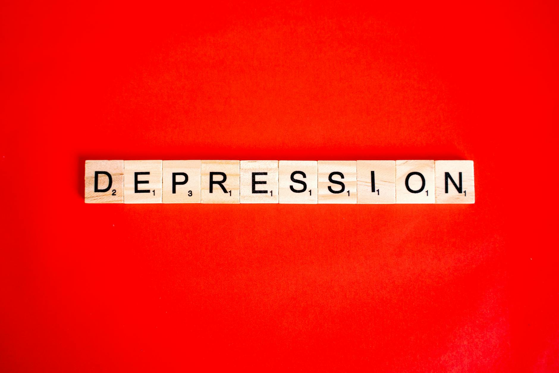 Word depression spelled with letter tiles on vibrant red background, highlighting mental health theme. - what causes anxiety disorder