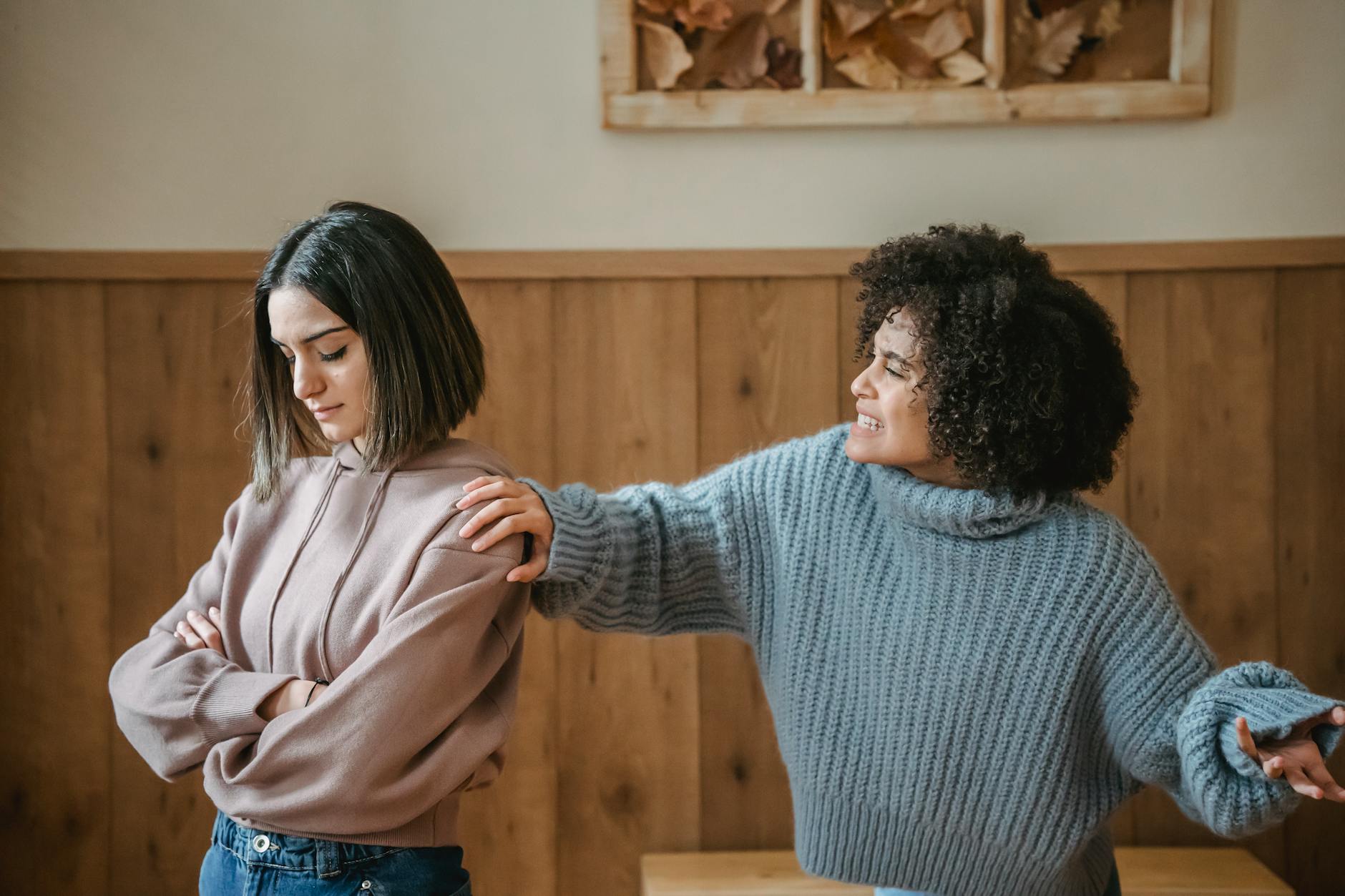 Two young women in a serious discussion in a cozy room setting. - cbt for winter negative self-talk