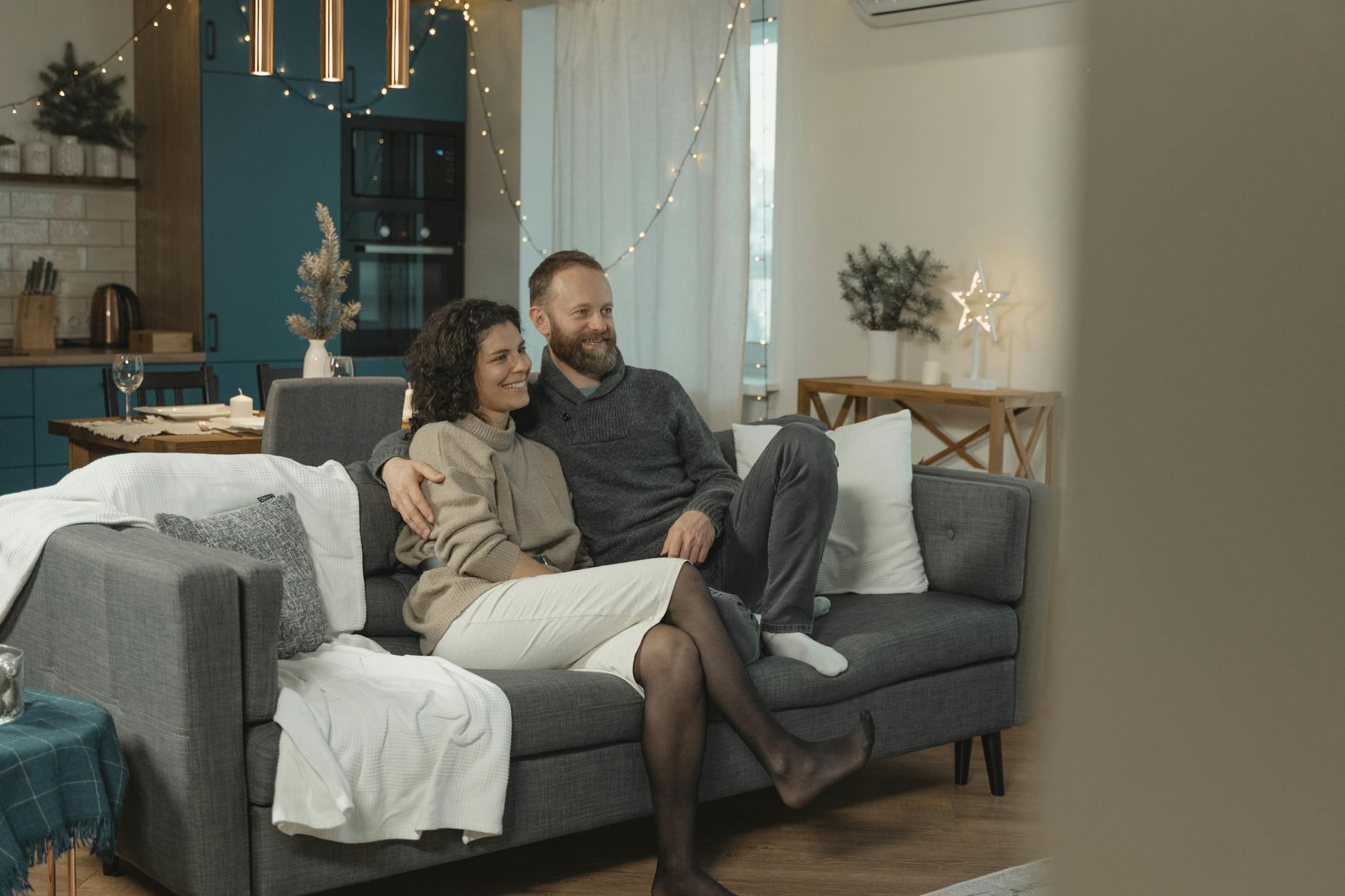Couple sitting together in a cozy, modern living room, enjoying a relaxing day indoors. - couples therapy holiday season