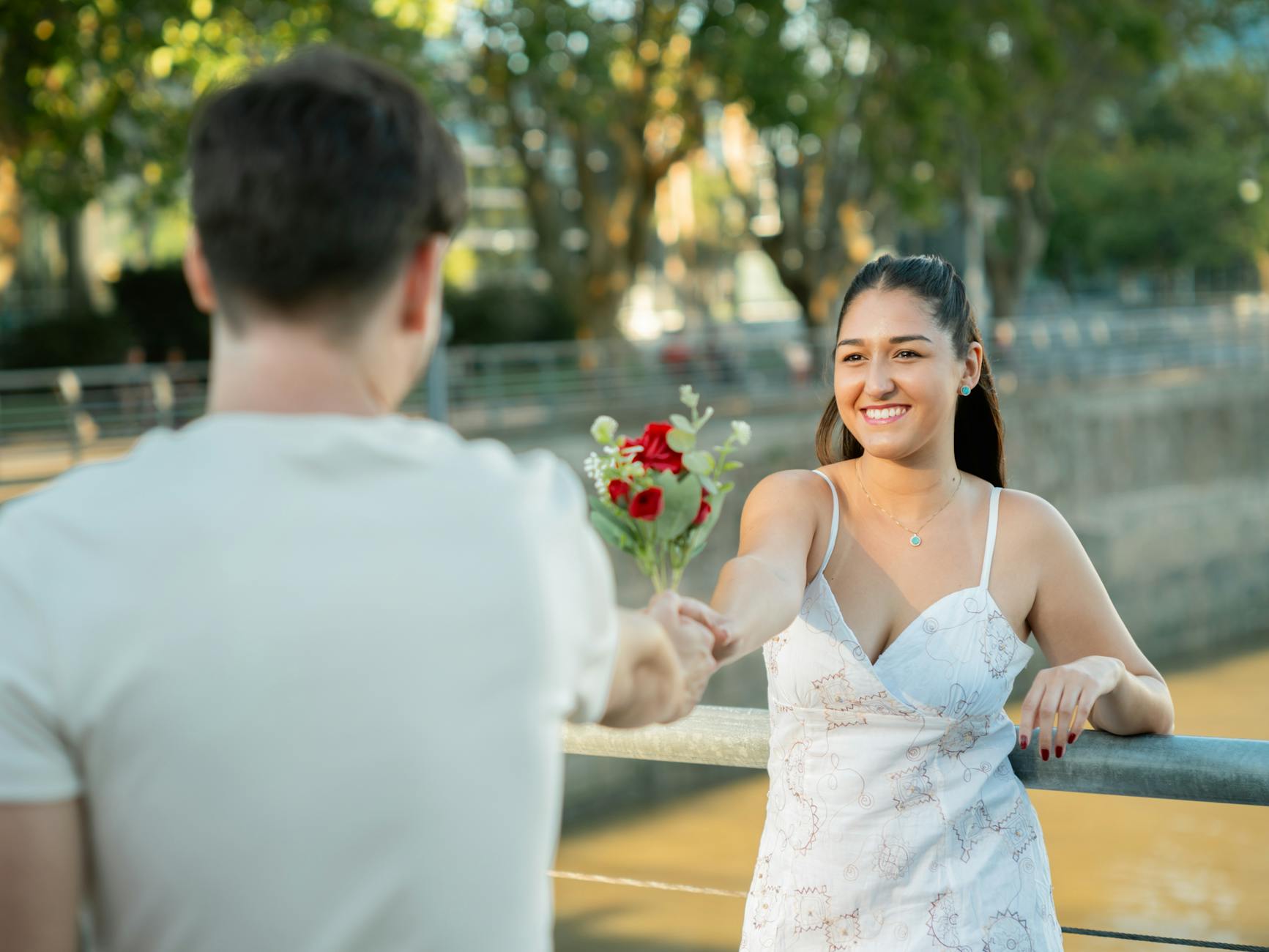 Young couple exchanging roses by the riverside in Buenos Aires, capturing a romantic moment. - good first date questions