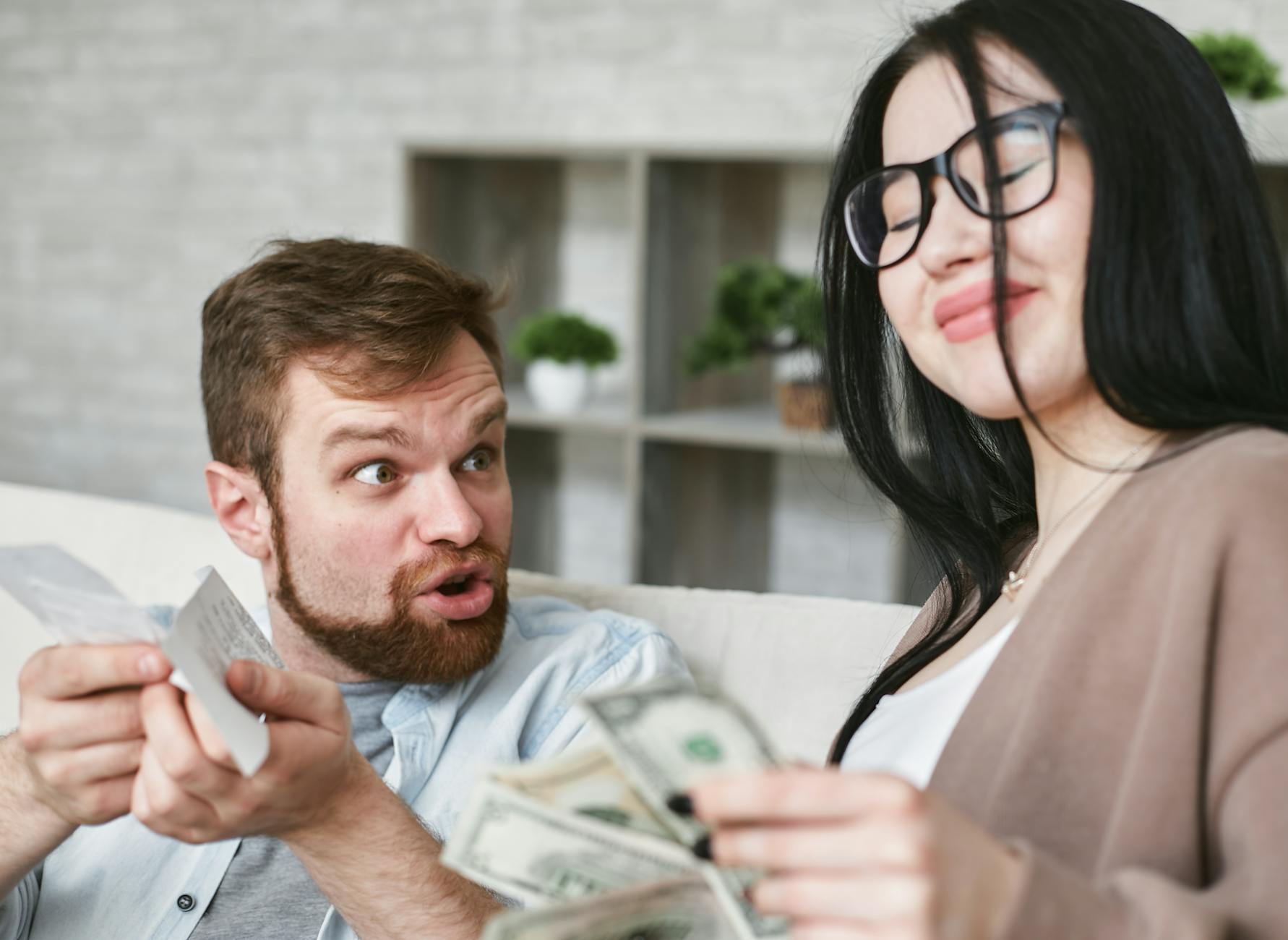 Interracial couple arguing over bills and cash at home. - holiday financial stress relationships