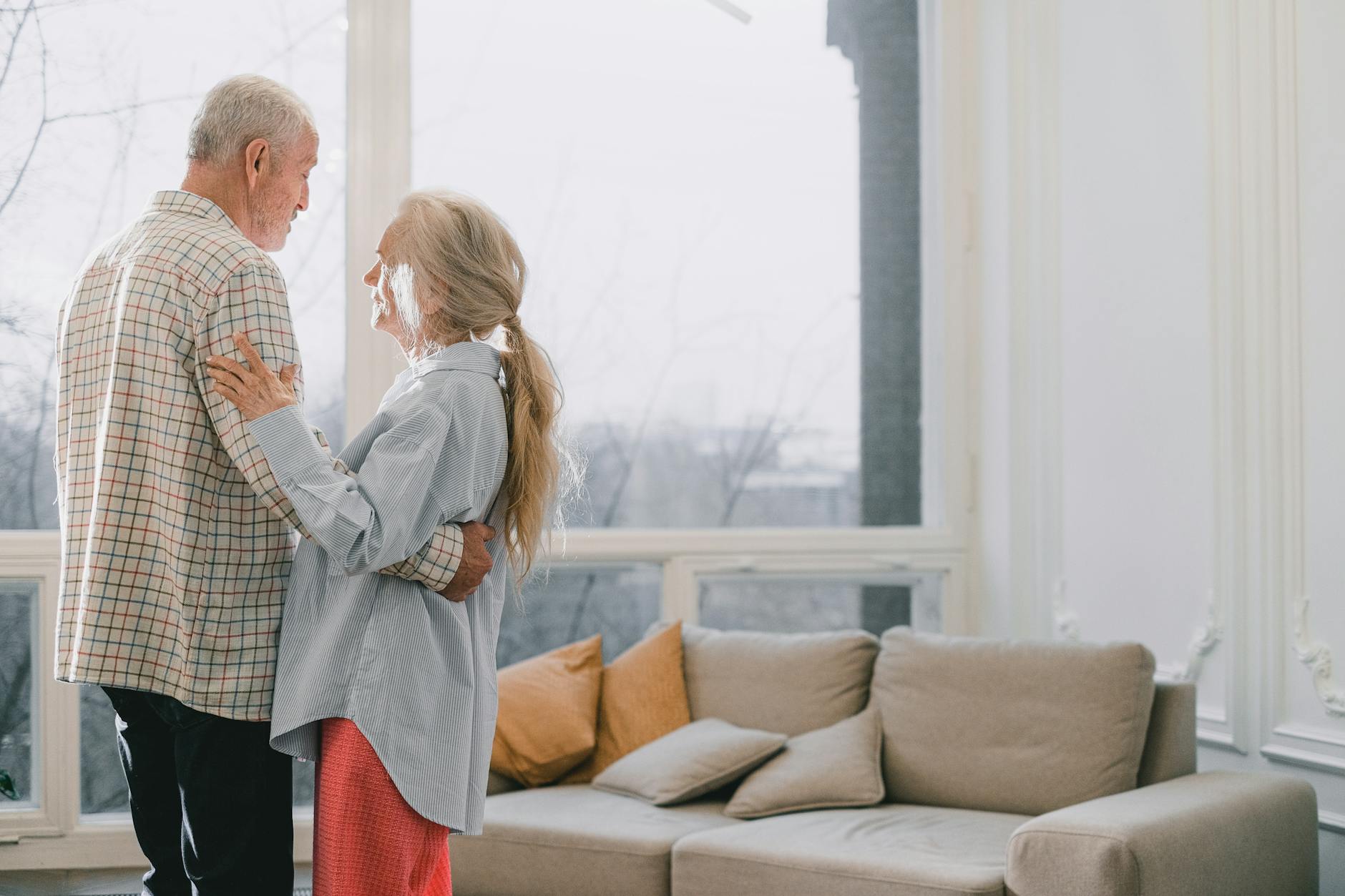 A senior couple shares a tender dance in a bright, cozy living room. - maintain romance long term