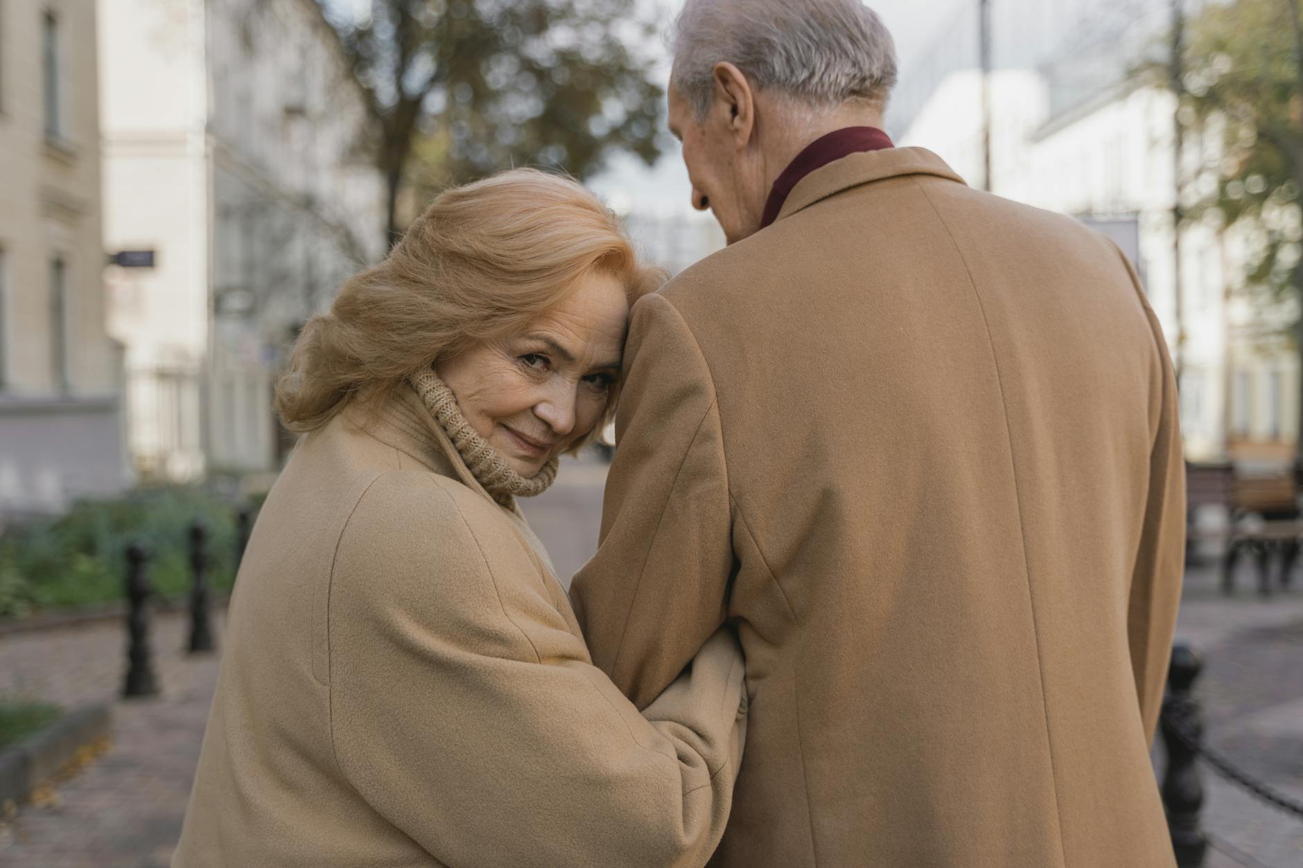 Tender moment of senior couple embracing outdoors in fall, exuding warmth and love. - maintain romance long term