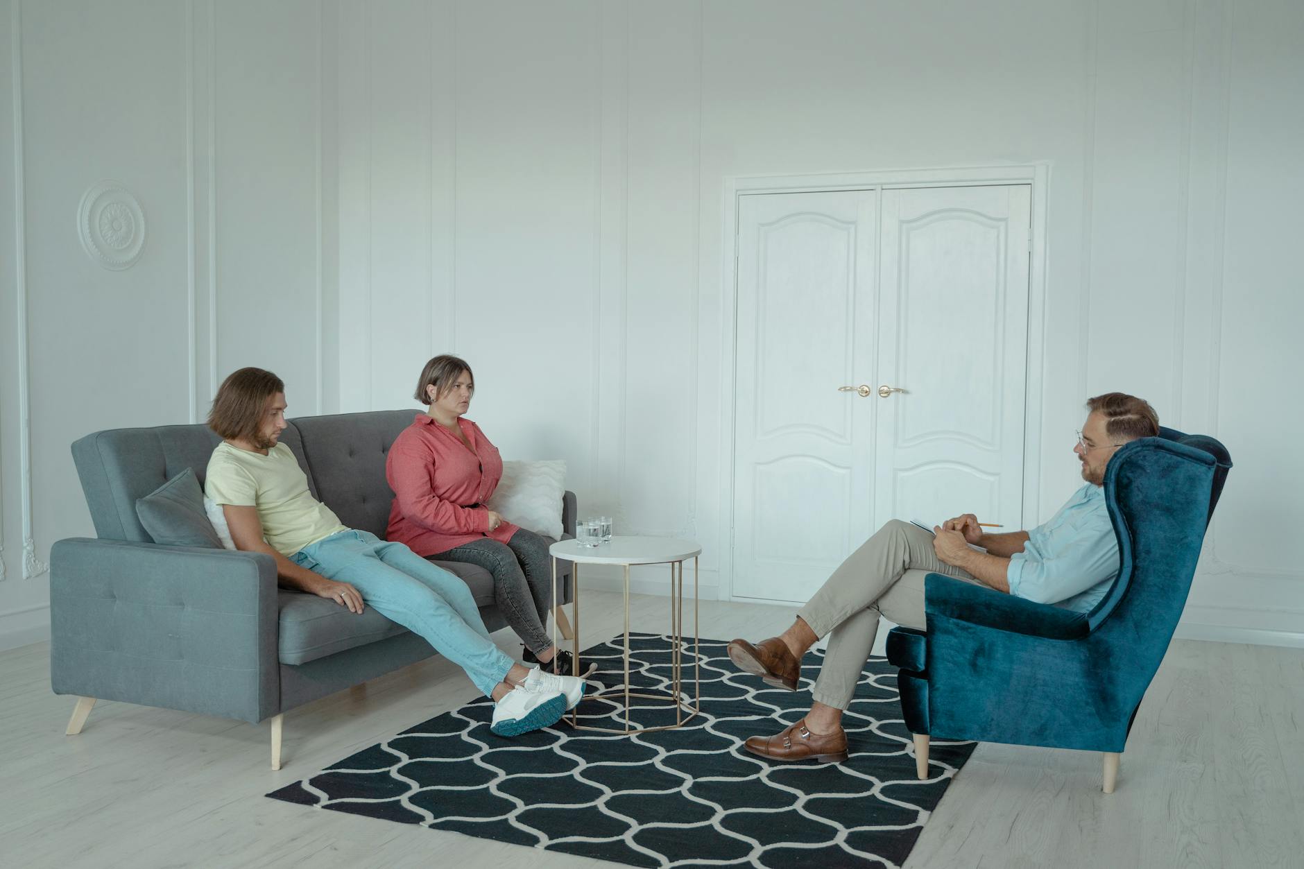 A married couple consulting with a therapist during a session in a modern office space. - marriage advice to avoid