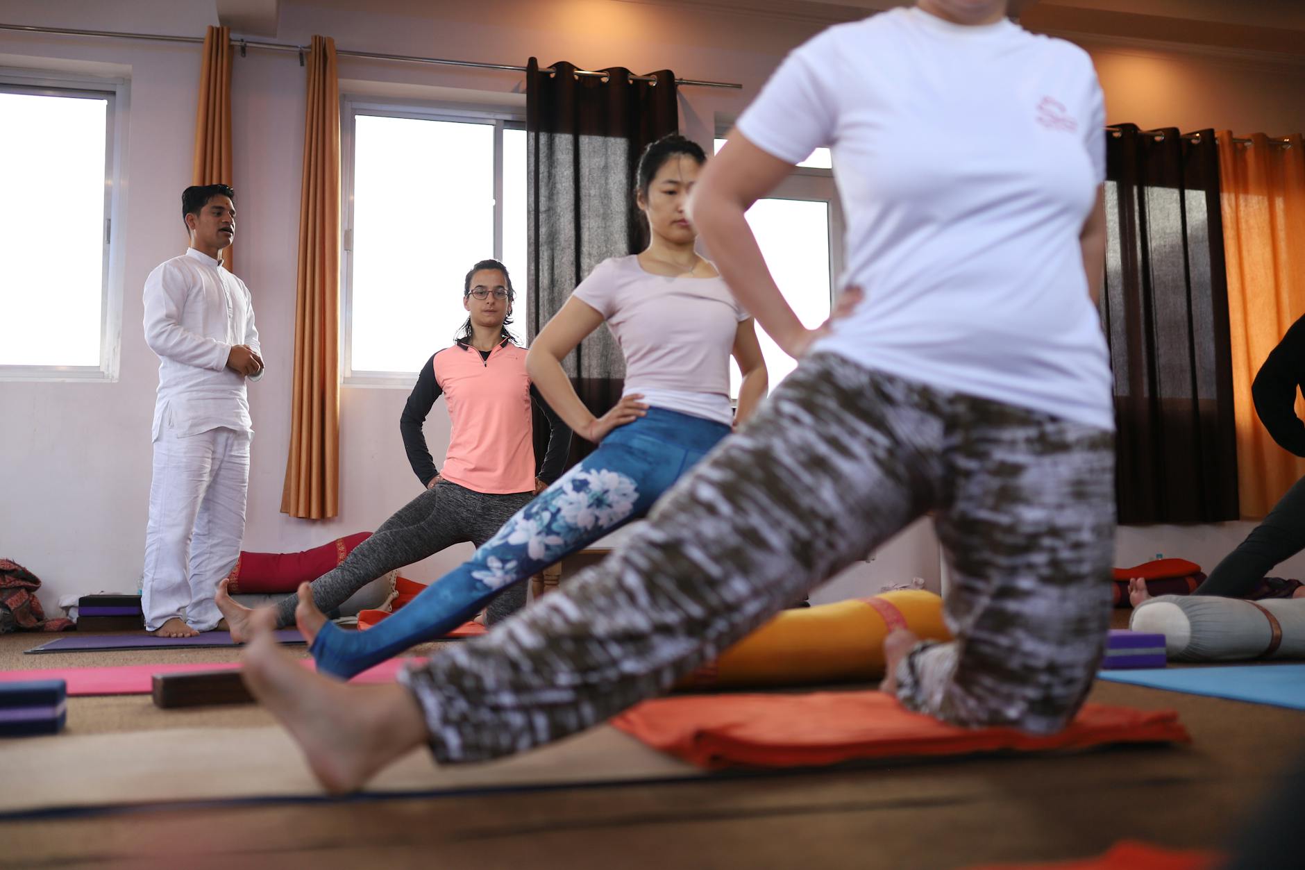 Group yoga session indoors with diverse students in Rishikesh yoga studio. - mindfulness techniques financial stress