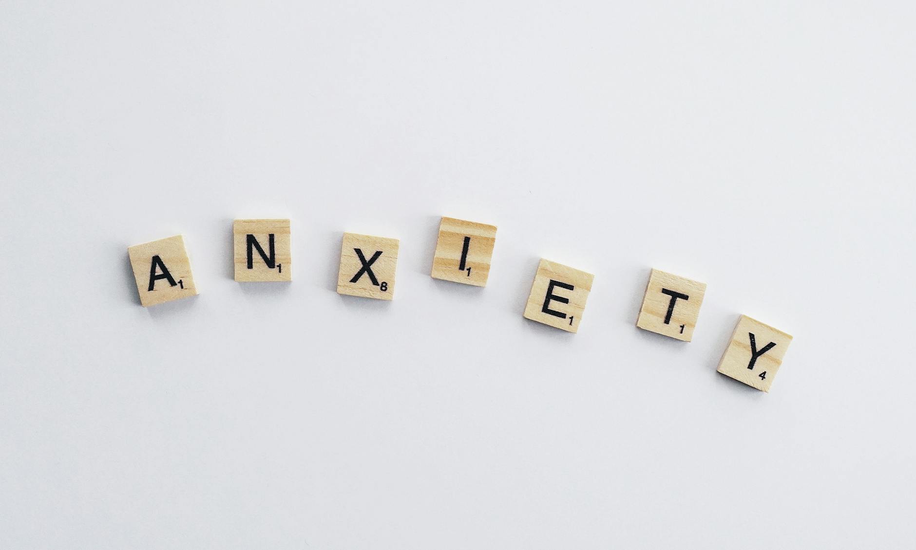 Wooden tiles on a white background spell anxiety, symbolizing mental health awareness. - mindfulness for winter anxiety