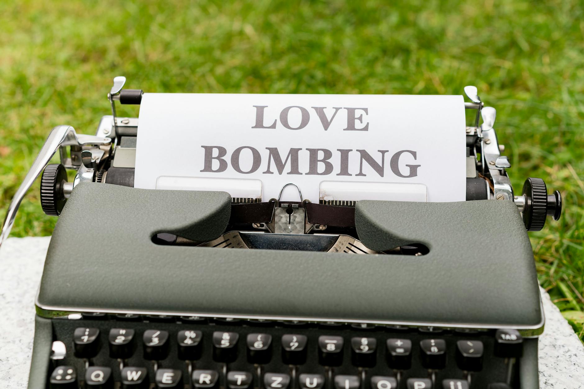 A vintage typewriter displaying the phrase 'Love Bombing' outdoors, symbolizing emotional manipulation. - narcissistic abuse recovery