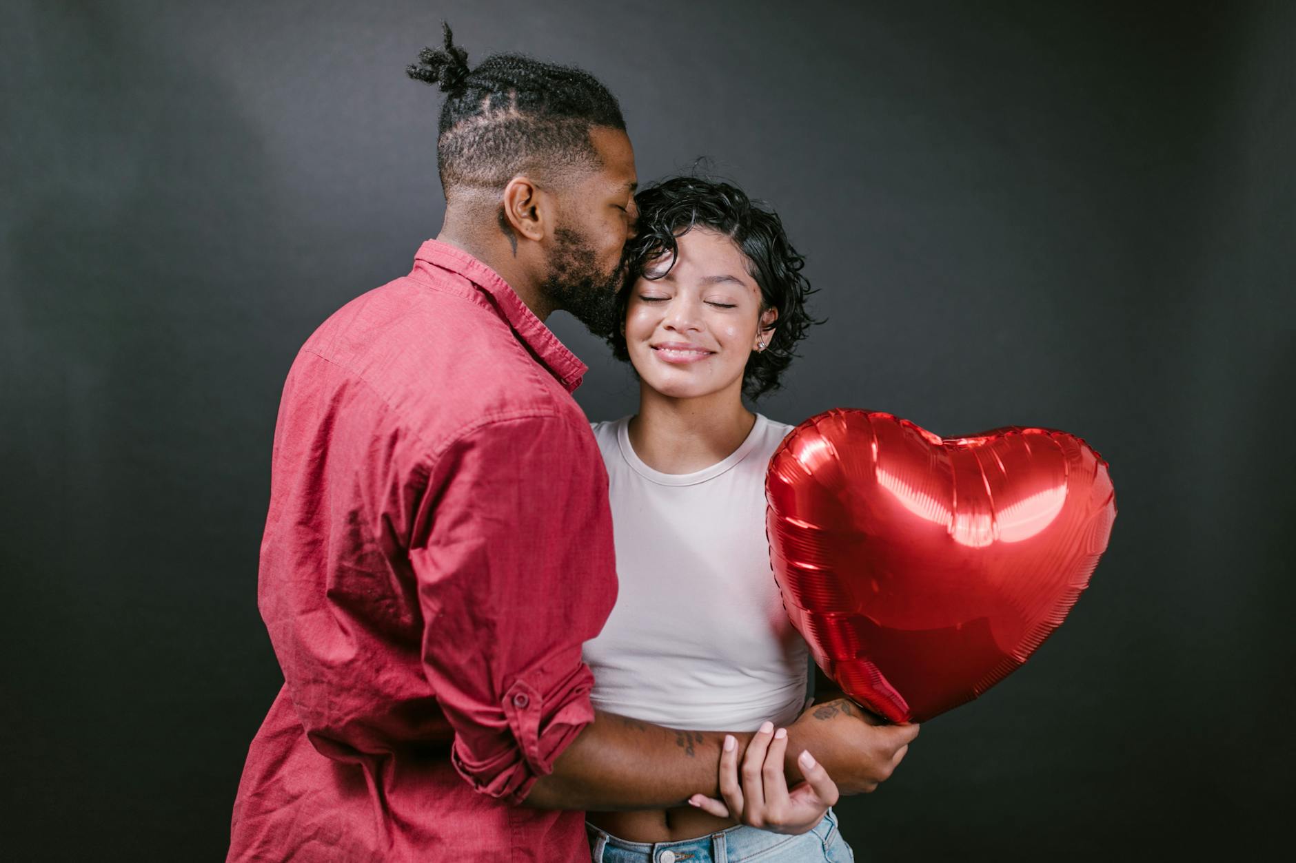 A loving couple embraces while holding a heart-shaped balloon, celebrating romance. - post valentine's relationship expectations