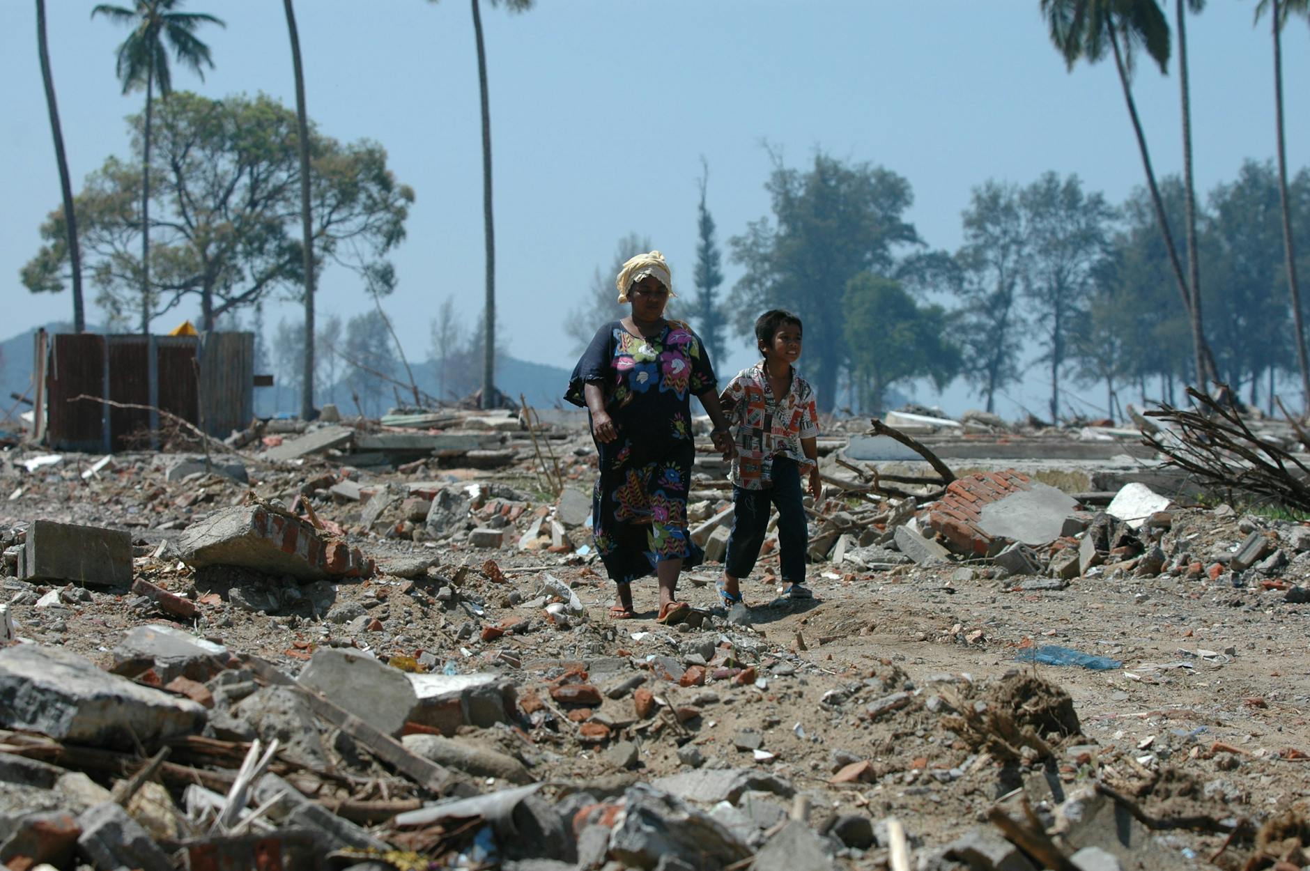 Two people walk through debris in Banda Aceh, Indonesia after a devastating tsunami. - rebuild trust in relationship
