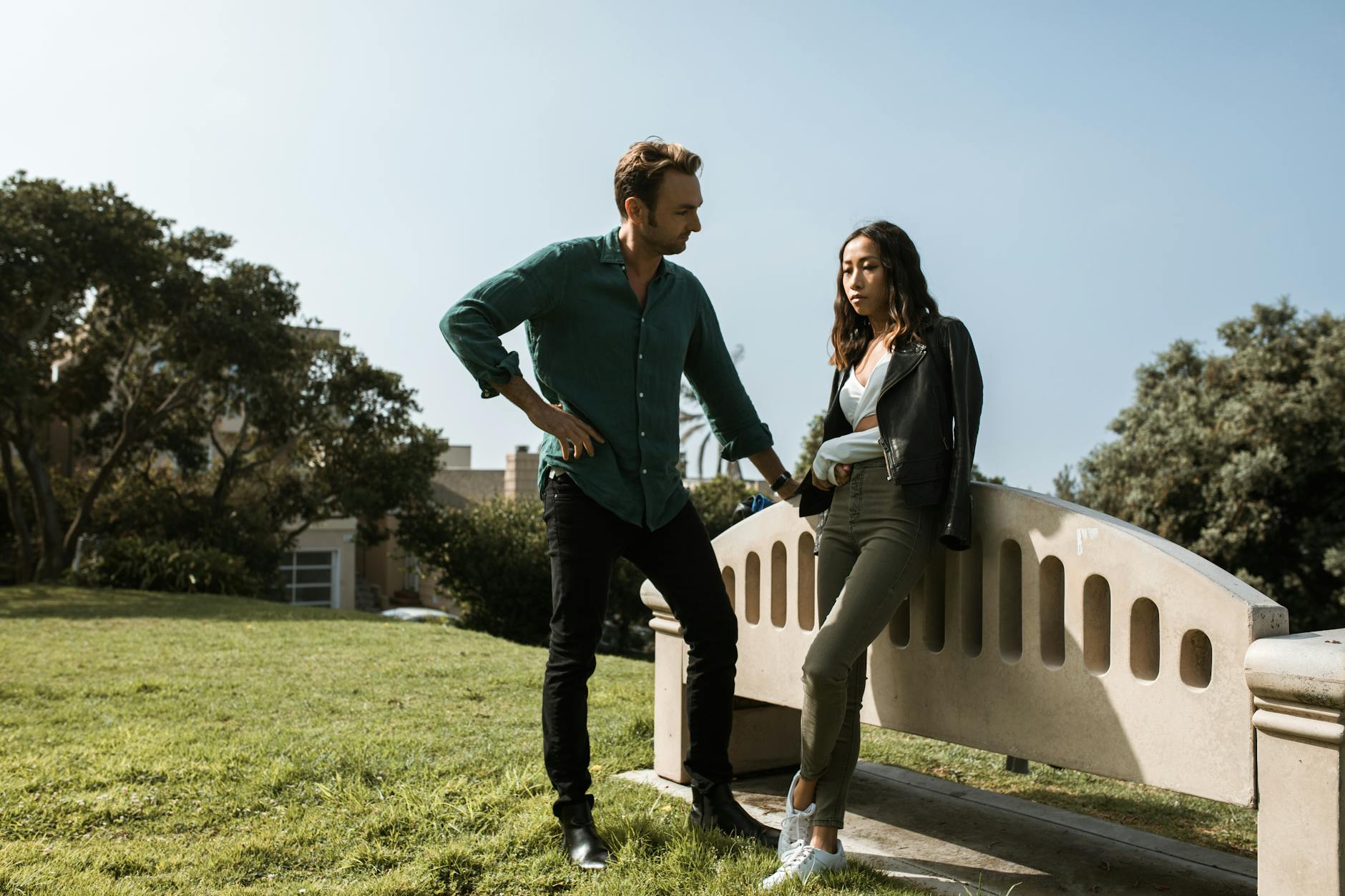 A couple in a tense discussion in a park setting, conveying relationship conflict. - relationship conflict resolution