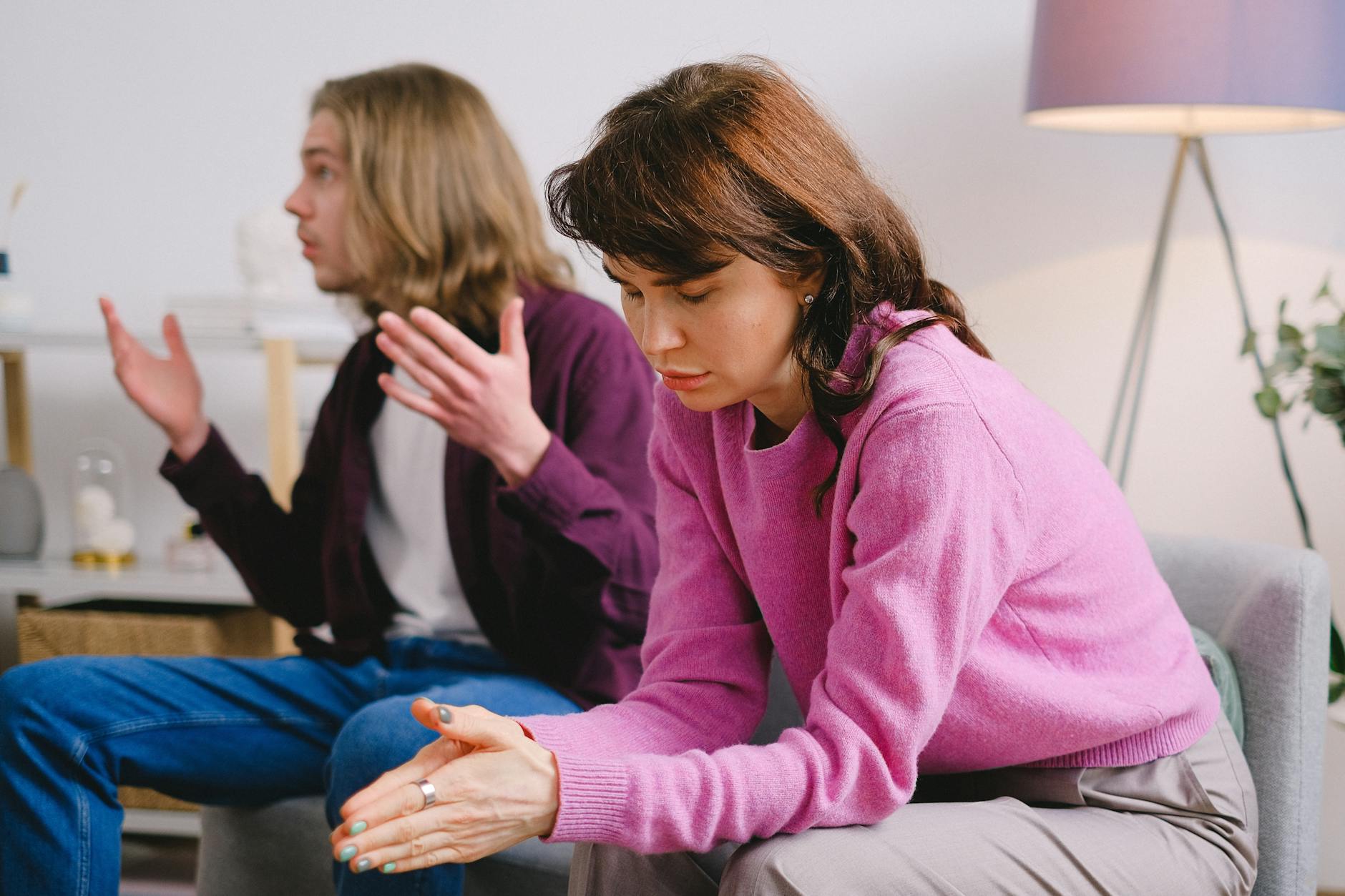 A couple having a serious discussion indoors; one looks upset while the other gestures expressively. - how to resolve conflict