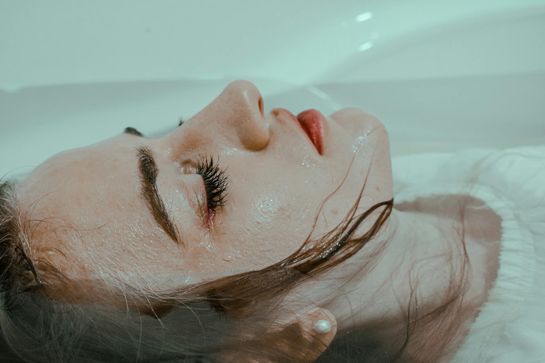A young woman with closed eyes in a bathtub, embodying peace and tranquility. - seasonal depression teens