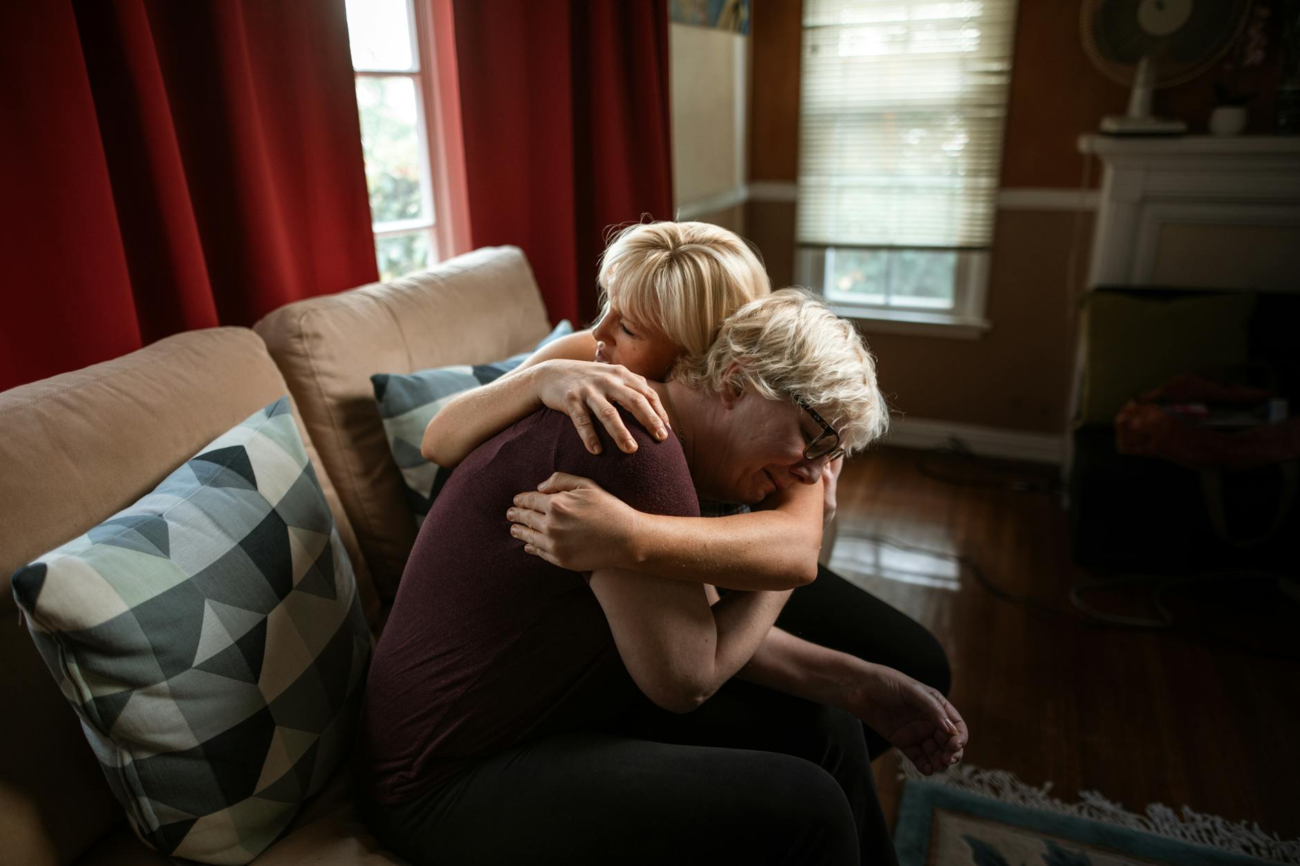 An emotional and supportive embrace between a couple on a sofa, showcasing affection and togetherness in a cozy home setting. - signs of narcissist partner