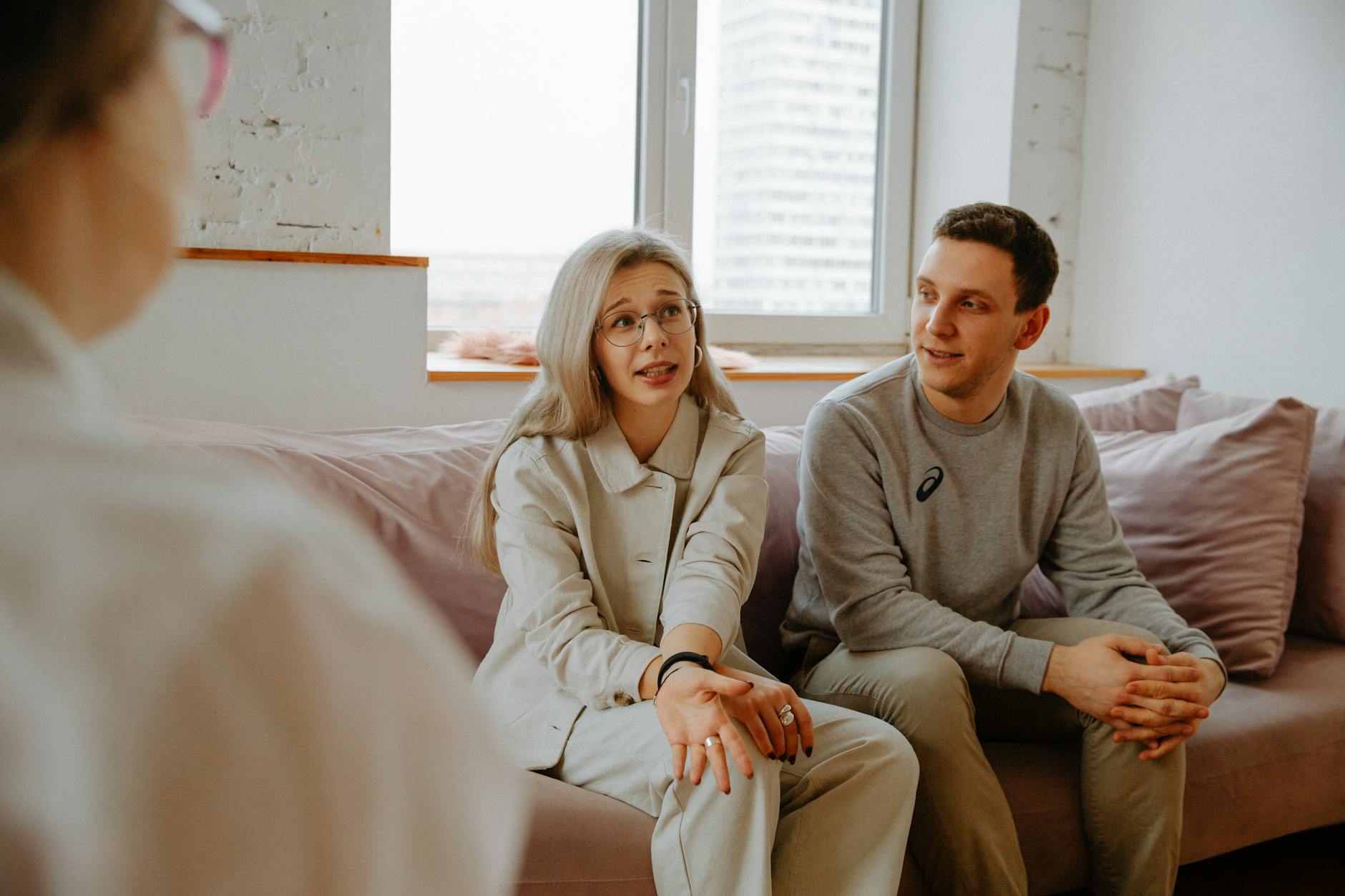 A couple and therapist engaged in a discussion during a therapy session indoors. - therapy for commitment issues