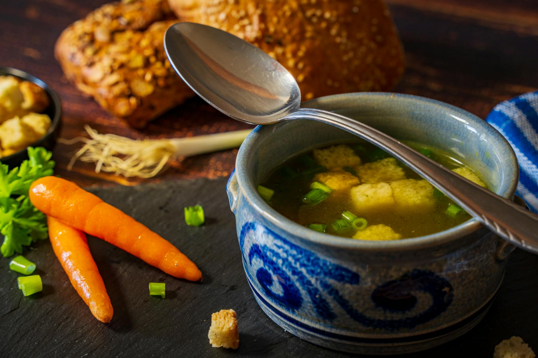 Delicious vegetable broth with croutons served in a blue bowl, perfect for a comforting winter meal. - winter blues natural remedies