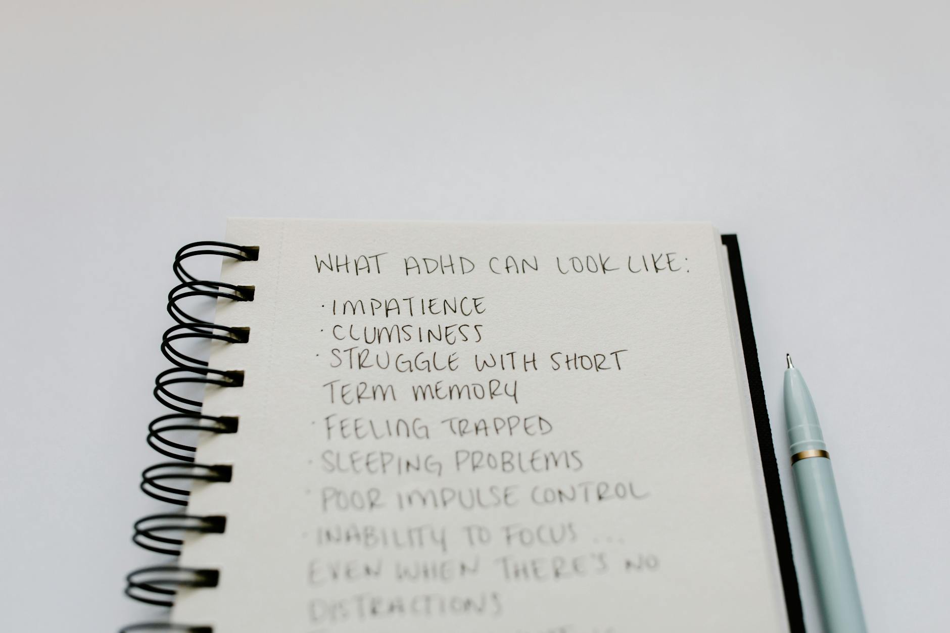 A notebook with handwritten ADHD symptoms like impatience and focus issues. - winter mental health gut health