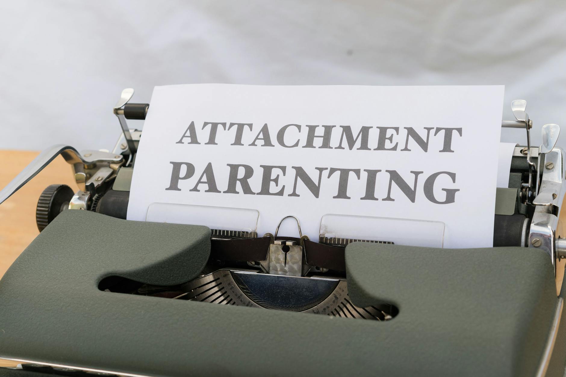 Close-up of a vintage typewriter with 'ATTACHMENT PARENTING' paper sheet. - winter proximity attachment styles